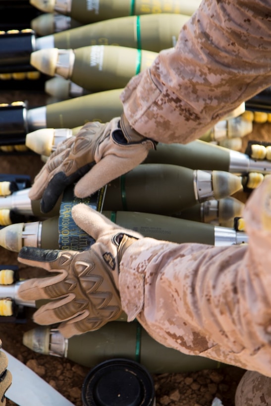 U.S. Marine explosive ordnance disposal (EOD) technicians with 1st EOD, Combat Logistics Battalion 1, Combat Logistics Regiment 1, 1st Marine Logistics Group, stick a block of C4 explosive onto 81mm high explosive mortars on a demolition range at Al Asad Air Base, Iraq, Nov. 9, 2015. The C4 is used during a controlled detonation to rid high explosive 81mm mortars that were deemed unserviceable by an ammo technician. 1st EOD is an element of Special Purpose Marine Air Ground Task Force - Crisis Response - Central Command, in support of Combined Joint Task Force – Operation Inherent Resolve. (U. S. Marine Corps photo by Staff Sgt. Nathan O. Sotelo/Released)