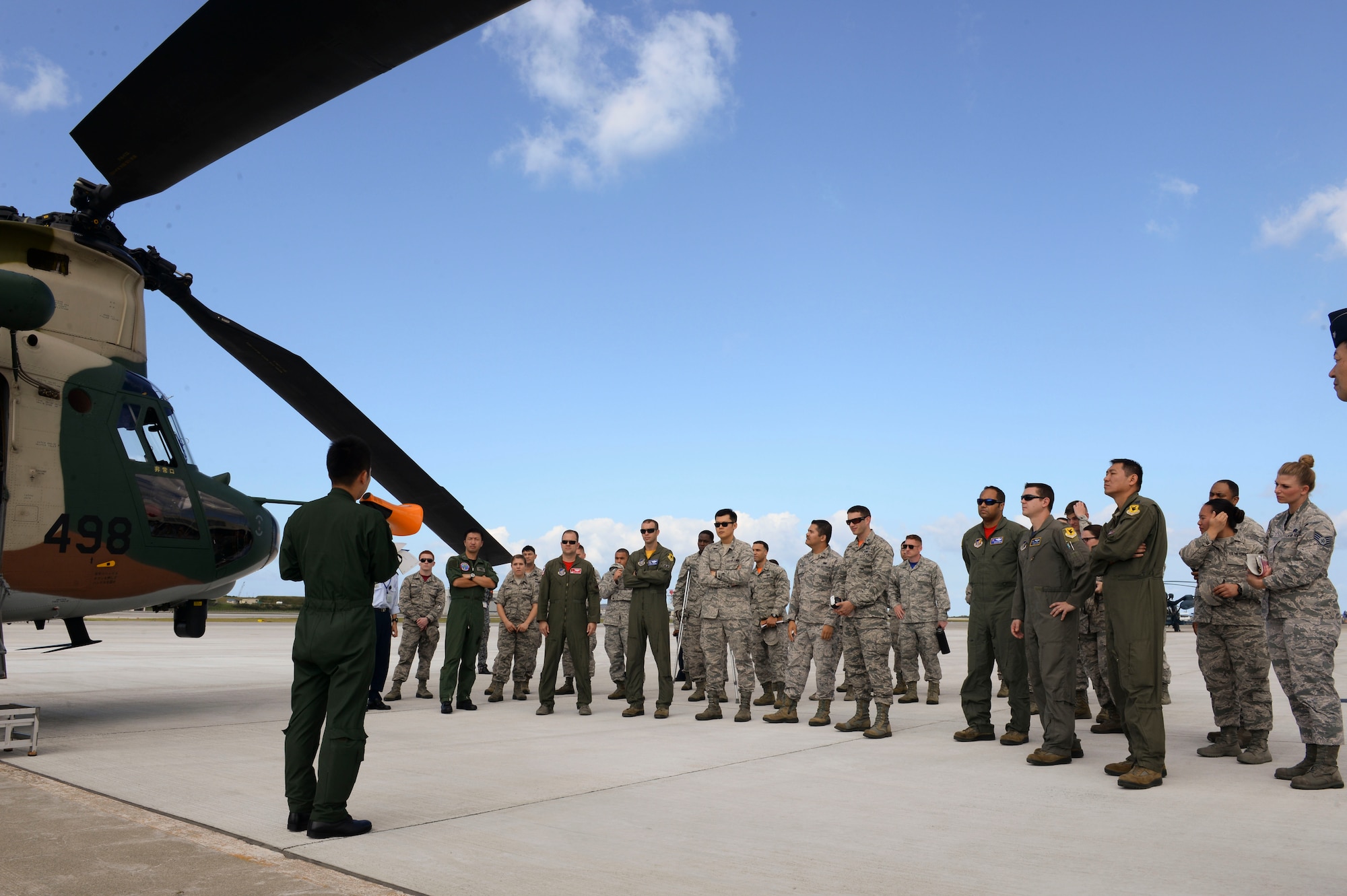 U.S. Airmen from Kadena Air Base, Japan, learn about Japan Air Self-Defense Force helicopter airlift capabilities next to a Ch-47J Chinook during a wing exchange tour Nov. 20, 2015, on the flight line of Naha Air Base, Japan. Pilots and maintenance Airmen from Naha Air Base provided an interactive tour of their several airframes, to include the F-15 Eagle, UH-60J Black Hawk, and E-2C Hawkeye. (U.S. Air Force photo by Senior Airman John Linzmeier/Released)  
