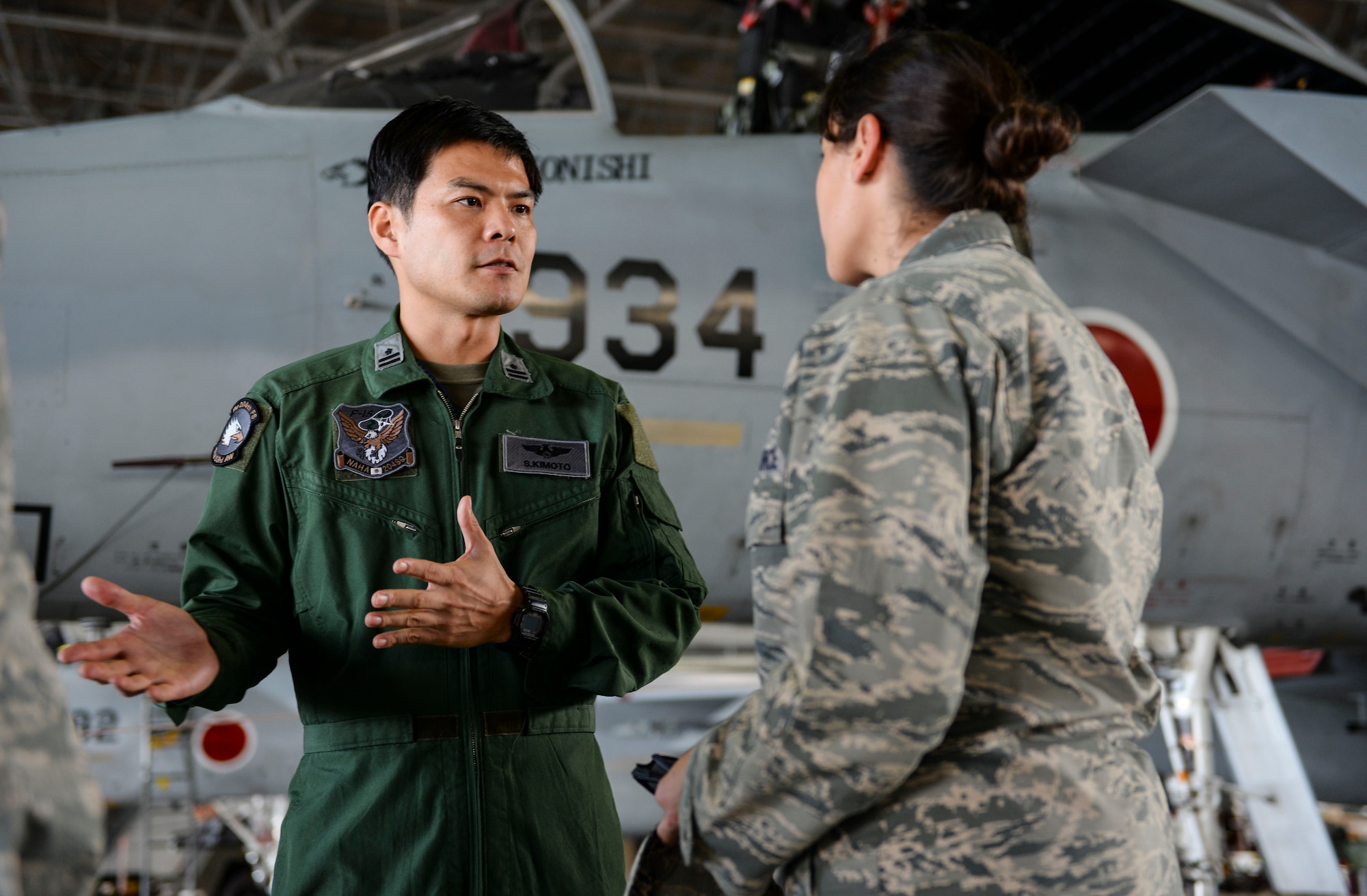 Japan Air Self-Defense Force Maj. Shingo Kimoto, 204th Fighter Squadron F-15 Eagle pilot, answers questions about his airframe during a wing exchange tour Nov, 20, 2015, at Naha Air Base, Japan. Approximately 40 Airmen from Kadena Air Base were provided an extensive tour of the base to improve their understanding of their local counterparts. (U.S. Air Force photo by Senior Airman John Linzmeier/Released)  