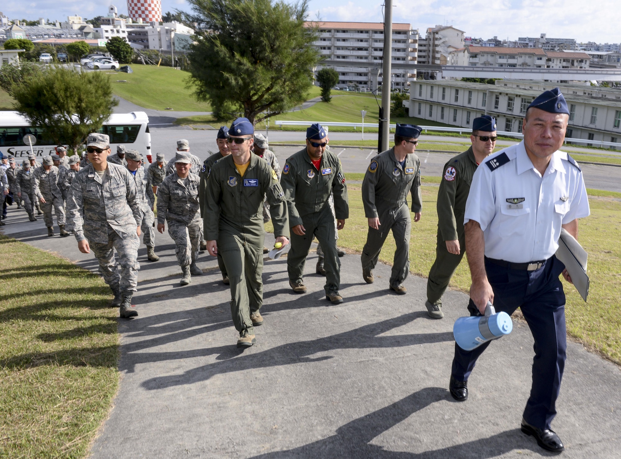 Japan Air Self-Defense Force Lt. Col. Yutaka Hori, 83rd Wing Headquarters director of administration, leads Kadena Airmen up a hill to observe a historical site Nov. 20, 2015, at Naha Air Base, Japan. The U.S. Airmen were provided an extensive tour of the base as part of a wing exchange program, held to improve the understanding of each Air Force’s mission and capabilities. (U.S. Air Force photo by Senior Airman John Linzmeier/Released)  