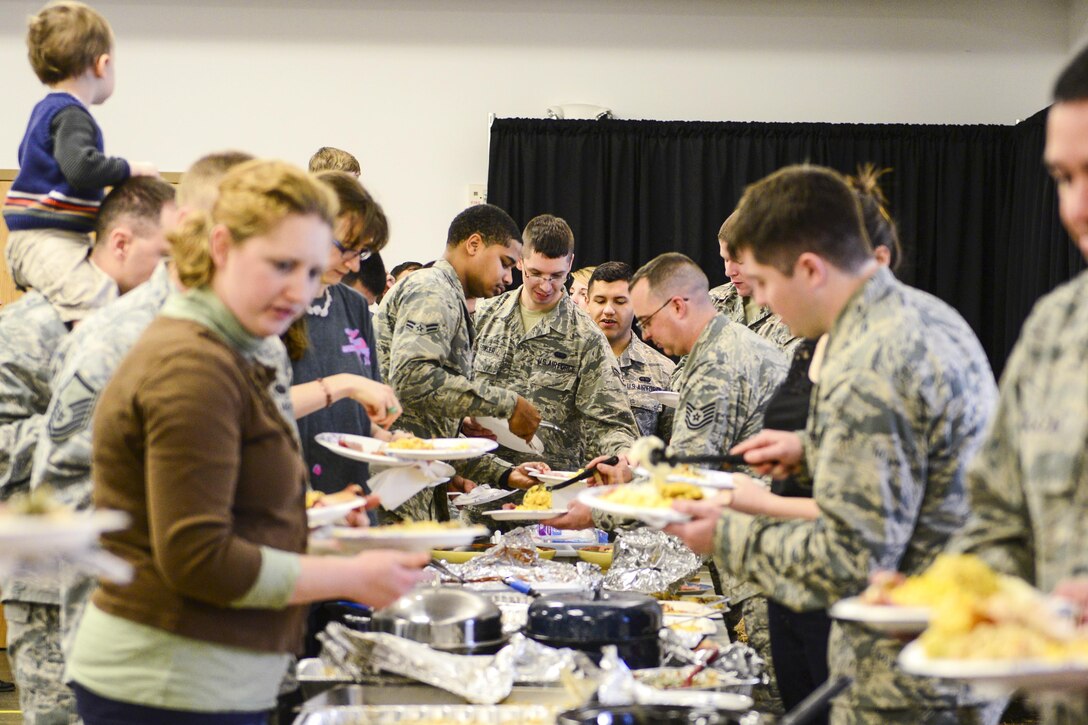 Airmen assigned to the 354th Communications Squadron enjoy family and food at an early Thanksgiving potluck dinner on Eielson Air Force Base, Alaska, Nov. 20, 2015. U.S. Air Force photo by Airman 1st Class Cassandra Whitman