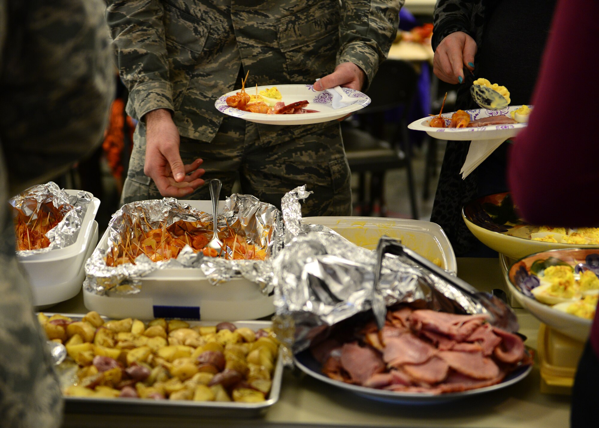 U.S. Air Force Airmen with the 354th Communications Squadron enjoy food at a Thanksgiving potluck Nov. 20, 2015, at Eielson Air Force Base, Alaska. The Airmen and their families cooked a variety of foods to share. (U.S. Air Force photo by Airman 1st Class Cassandra Whitman/Released)