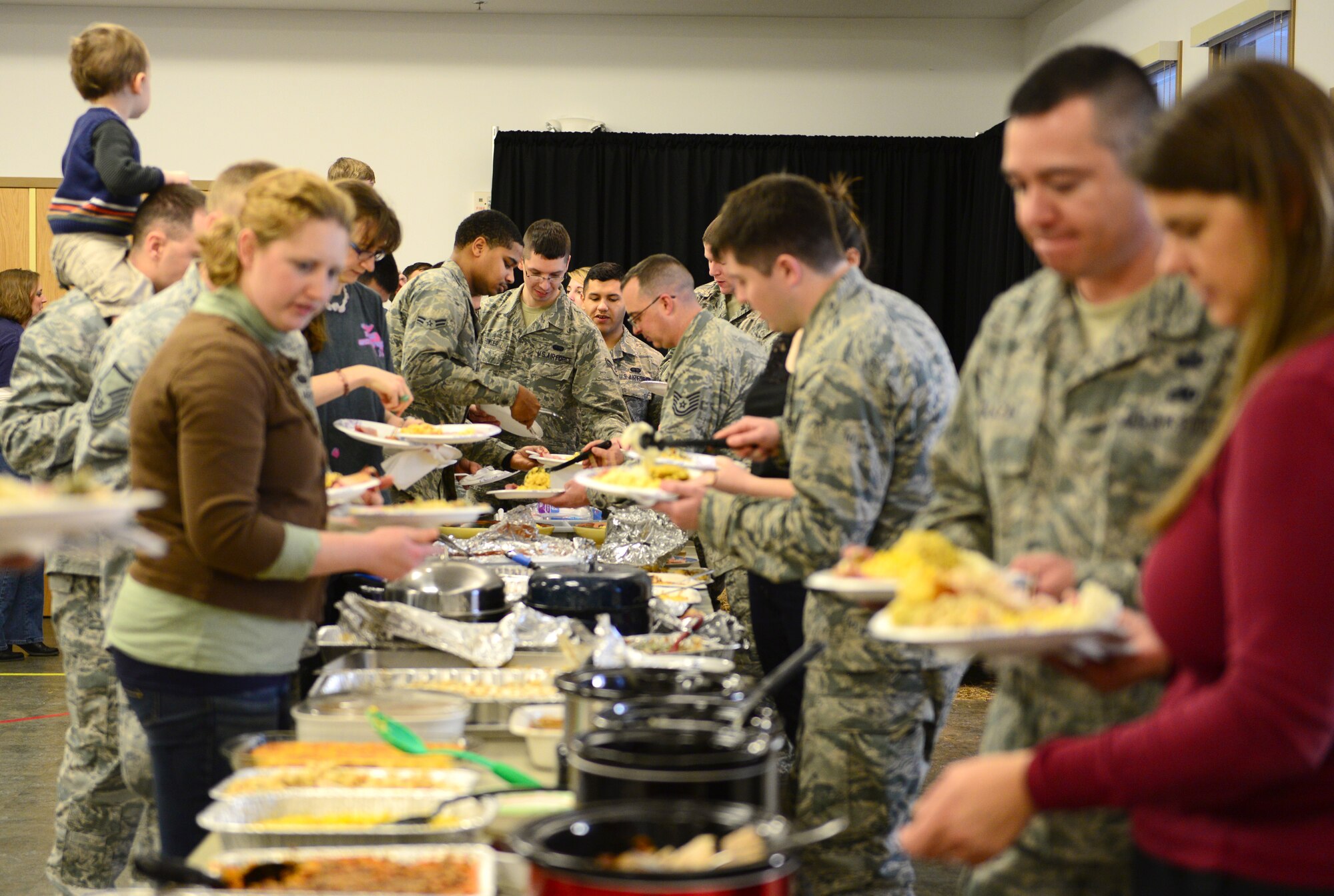 U.S. Air Force Airmen with the 354th Communications Squadron (CS) enjoy their families and food at a Thanksgiving potluck Nov. 20, 2015, at Eielson Air Force Base, Alaska. The 354th CS gathered for the holiday to promote esprit de corps. (U.S. Air Force photo by Airman 1st Class Cassandra Whitman/Released)