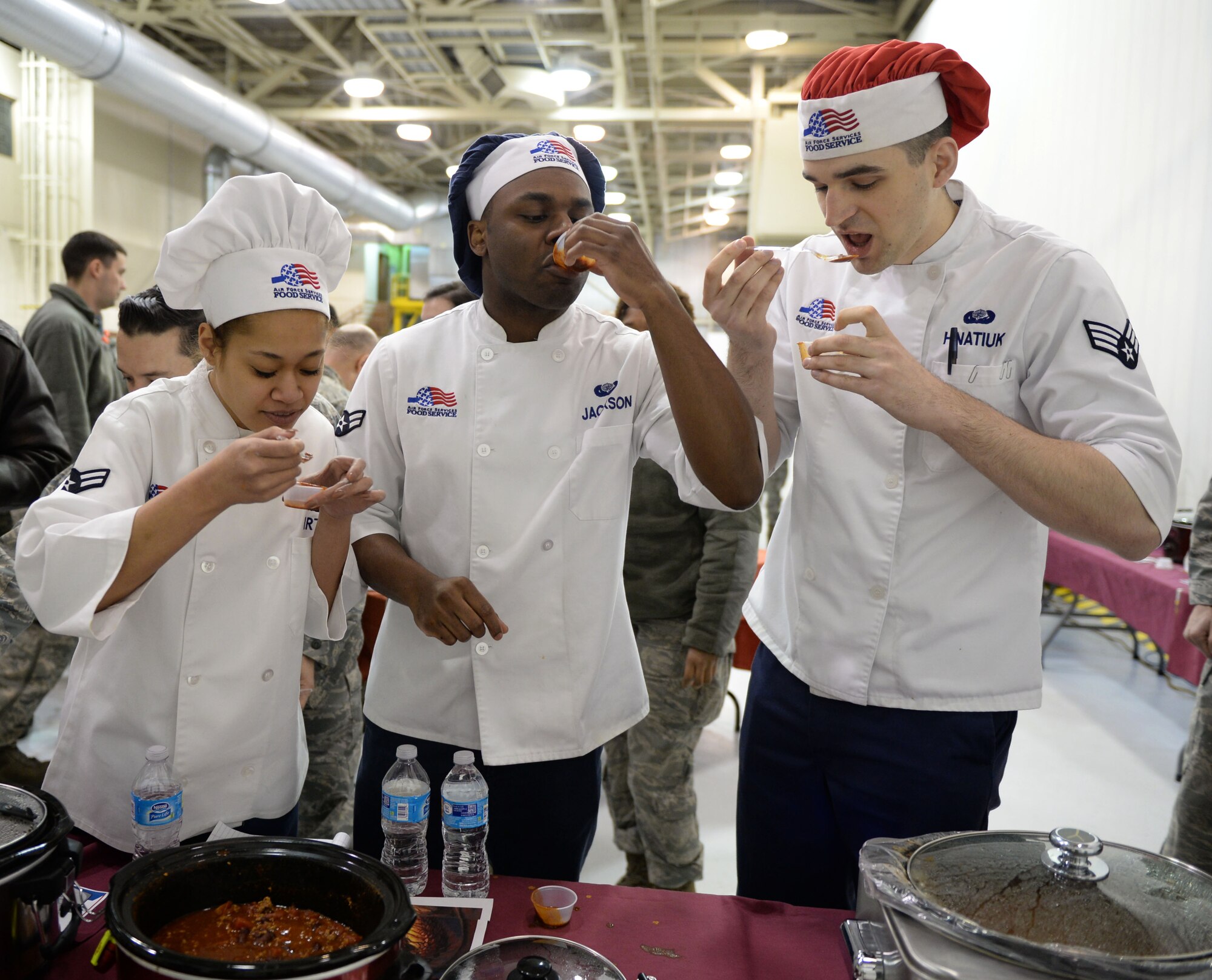 Judges from the 354th Force Support Squadron taste test various pots of chili during the 354th Maintenance Group chili cook off at Eielson Air Force Base, Alaska, Nov. 20, 2015. The judges savored 53 chili entries, ranging from mild to “dragon’s blood hot.” (U.S. Air Force photo by Senior Airman Racheal E. Watson/Released) 