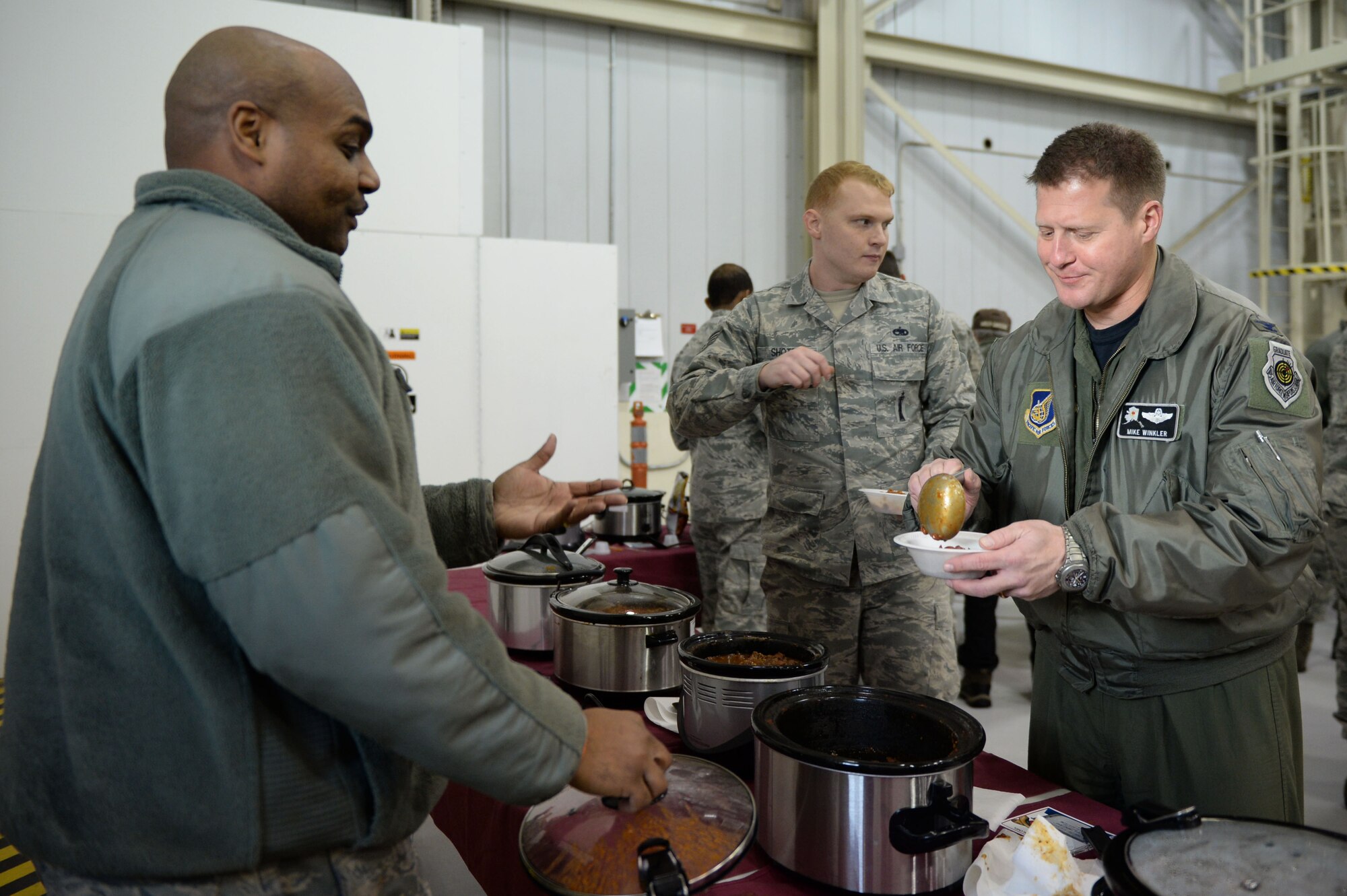 U.S. Air Force Master Sgt. Nicholas Williams, the 354th Maintenance Squadron avionics flight chief, talks with Col. Michael Winkler, the 354th Fighter Wing commander, during a maintenance group chili cook off at Eielson Air Force Base, Alaska, Nov. 20, 2015. The Thanksgiving gatherings gave Airmen who may not be returning home for the holiday a chance to bond with their Air Force family. (U.S. Air Force photo by Senior Airman Racheal E. Watson/Released) 
