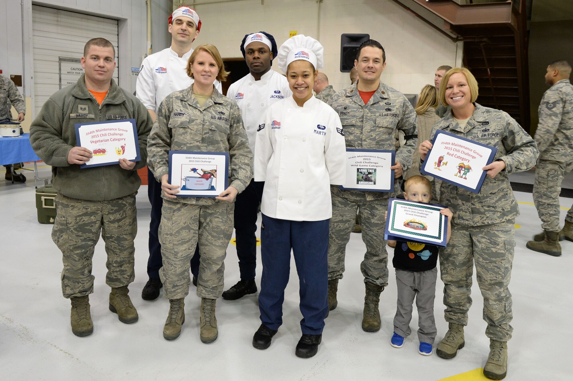 Winners of the 354th Maintenance Group chili cook off stand with judges from the 354th Force Support Squadron after the competition ended at Eielson Air Force Base, Alaska, Nov. 20, 2015. The maintenance group hosted the cook off to showcase Airmen’s culinary skills and encourage esprit de corps. (U.S. Air Force photo by Senior Airman Racheal E. Watson/Released) 