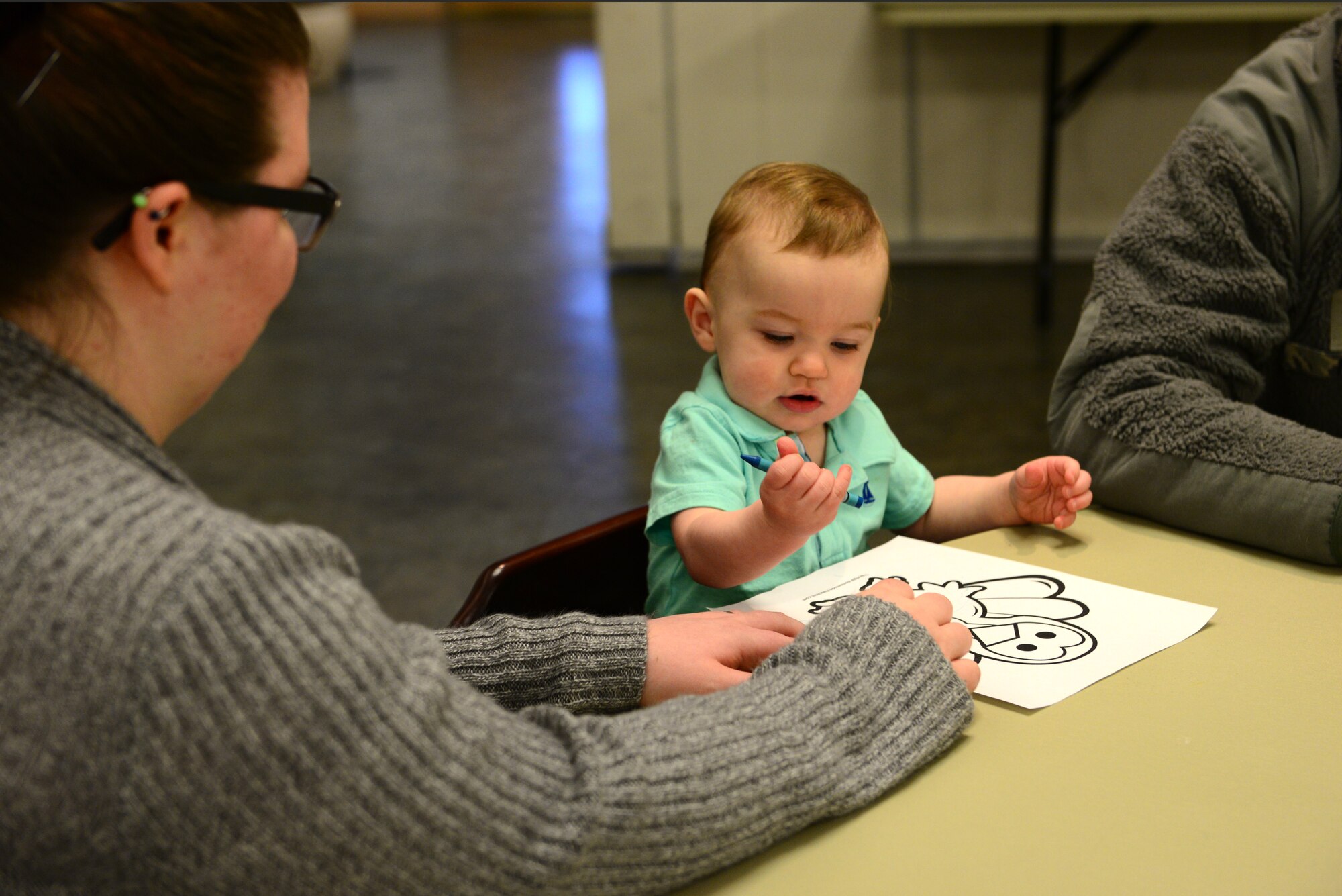 U.S. Air Force Airmen with the 354th Communications Squadron spend time with co-workers and their families at a Thanksgiving potluck Nov. 20, 2015, at Eielson Air Force Base, Alaska. This child enjoyed coloring a picture of a turkey with his mom and dad by his side. (U.S. Air Force photo by Airman 1st Class Cassandra Whitman/Released)