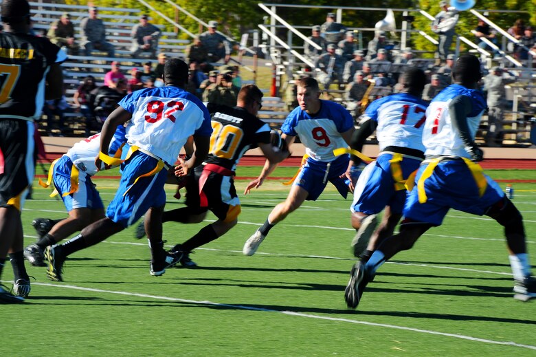 The Davis-Monthan Air Force Base Mustangs close in on a member of the Fort Huachuca Black Knights during the Turkey Bowl 2015 at Fort Huachuca, Ariz., Nov. 20, 2015. The Mustangs defeated the Black Knights 24-6 to secure their second consecutive Turkey Bowl championship. (U.S. Air Force photo by Airman 1st Class Mya M. Crosby/Released)