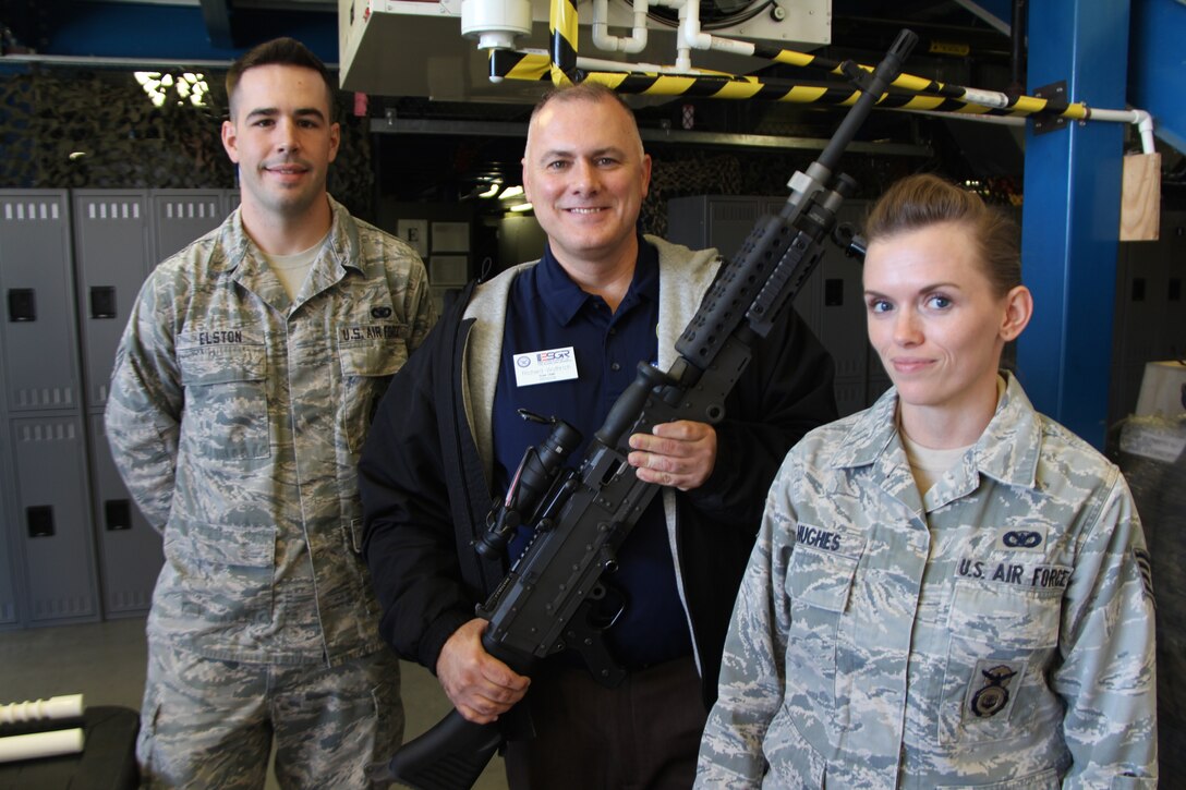 Senior Airman Zachary Elston (left) and Staff Sergeant Sarah Hughes (right) enjoy showing some of their 932nd Security Forces Squadron weapons to Richard Wuthrich, Employer Support of the Guard and Reserve speaker, during the 2015 Boss Day.  (U.S. Air Force photo by Maj. Stan Paregien)