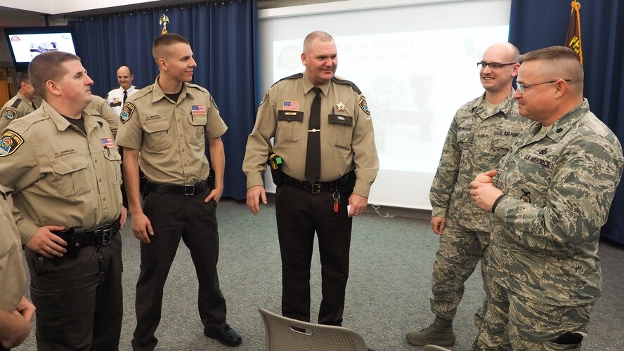 Lt. Col. Greg Peterson (right) and Master Sgt. Justin Siebenahler, 934th Security Forces Squadron, talk with Hennepin County Sheriff deputies during a holiday gathering Nov. 24. (Air Force Photo/Paul Zadach)