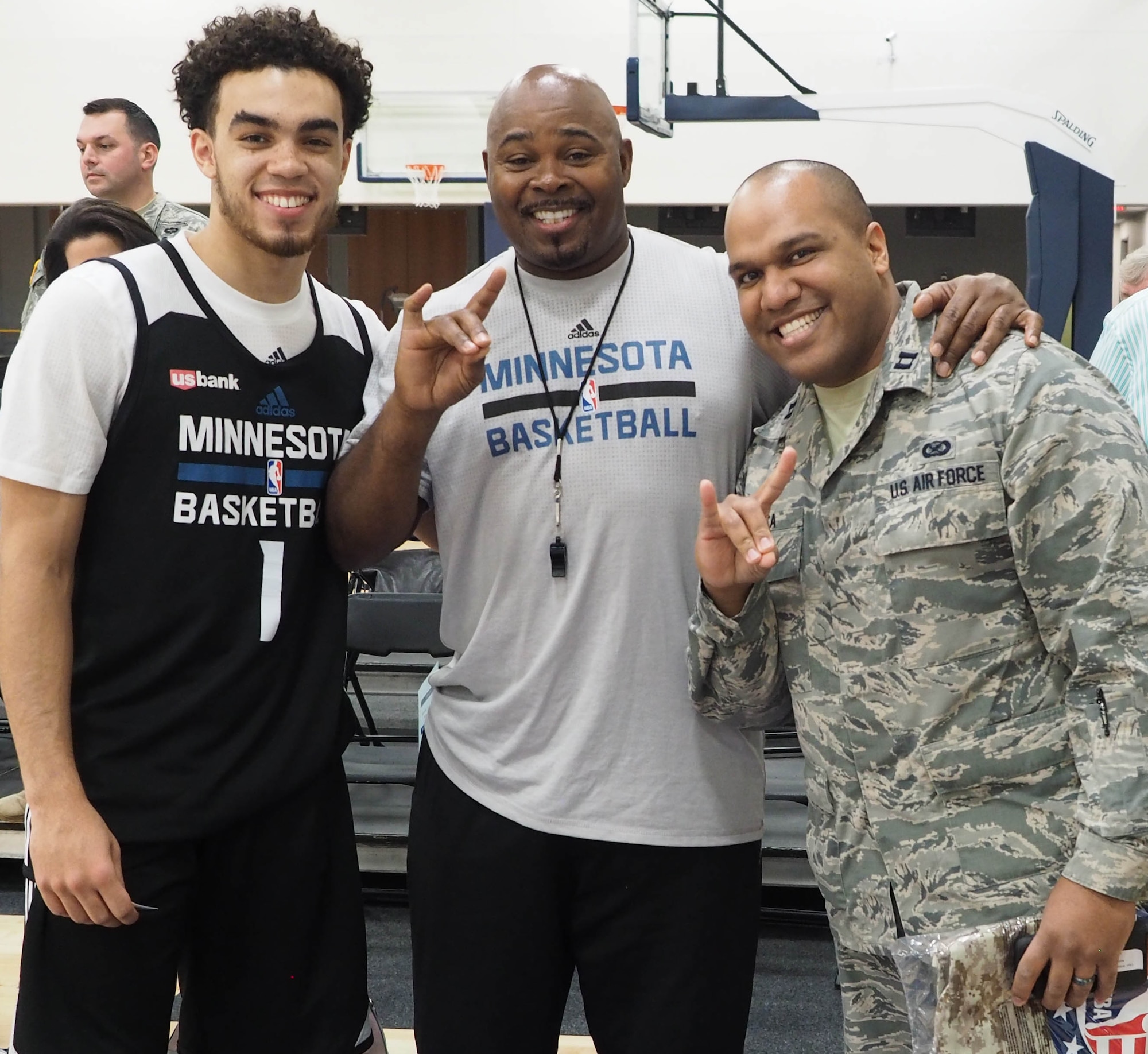 Capt. William-Joseph Mojica, 934th Airlift Wing Public Affairs, poses with Timberwolves Point Guard Tyus Jones and Assistant Coage Sidney Love during the Timberwolves' military open practice Nov. 24. (Air Force Photo/Paul Zadach)