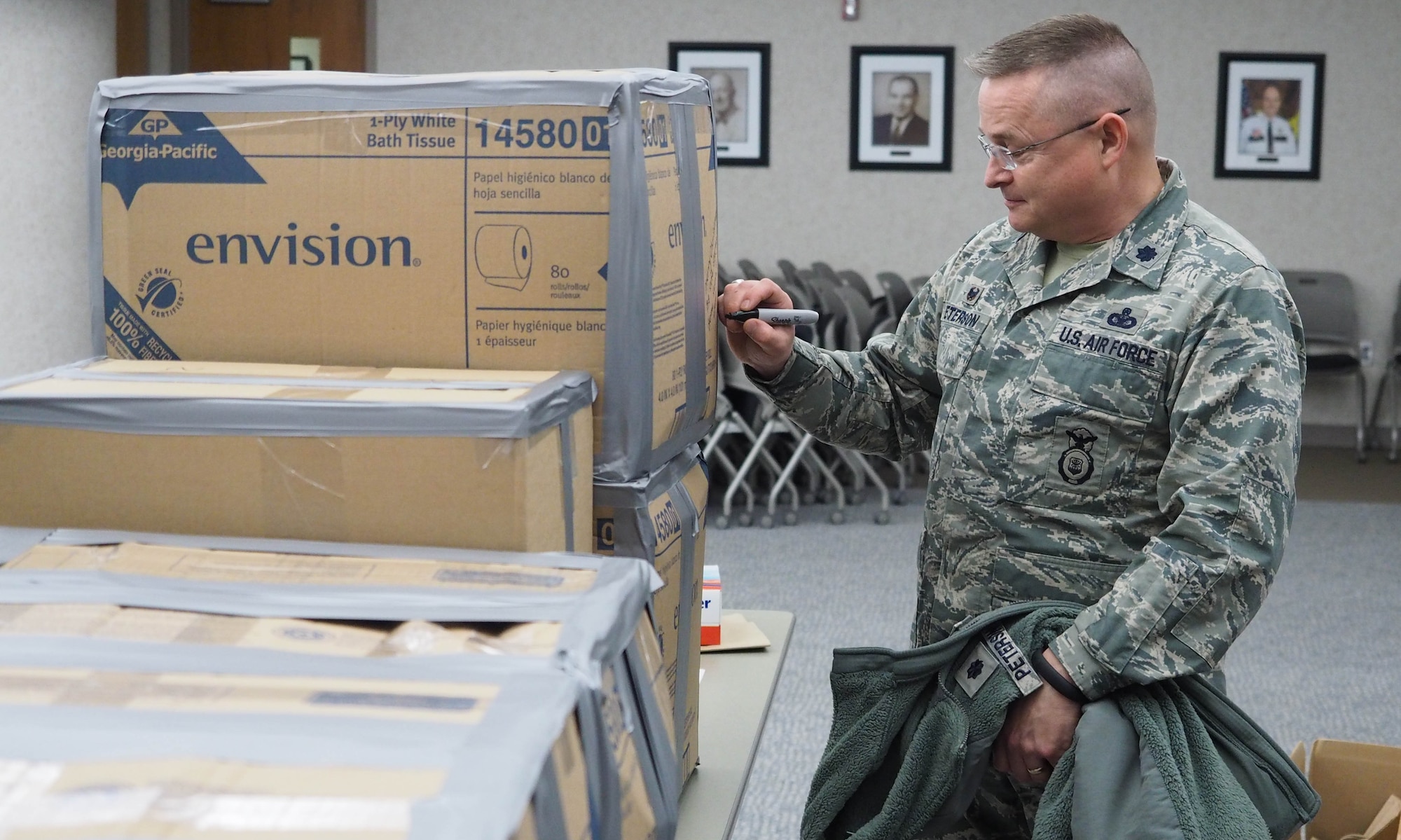 As a final touch, Lt. Col. Greg Peterson, 934th Security Forces Squadron commander, writes a holiday greeting to deployed military members on boxes before shipment. (Air Force Photo/Paul Zadach)
