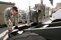 From left to right: Senior Airman Gregory Cantoni, Staff Sgt. Willie J. Nelson II, and Tech Sgt. Luke Andrews, 69th Aerial Port Squadron air transportation specialists, inspect and secure a Halvorsen Loader after training during the unit training assembly here during the month of November. A Havlorsen Loader is a rapidly deployable, high-reach mechanized aircraft loader that can transport and lift up to 25,000 pounds of cargo and load it onto military and civilian aircraft. (U.S. Air Force photo by Staff Sgt. Kat Justen)

