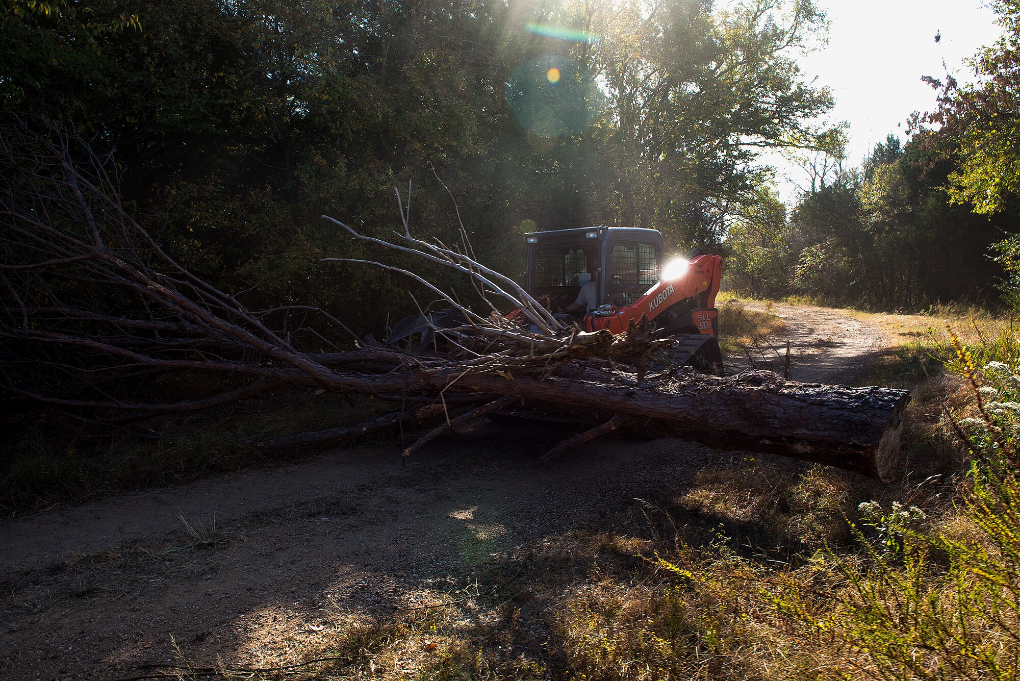 Airmen from the civil engineering squadrons of the 137th Air Refueling Wing, Oklahoma City, and the 138th Fighter Wing, Tulsa, Okla., use a  Kubota SVL 90-2 compact tractor to clear a downed tree during a debris clearance training at Camp Gruber, Oct. 19-23, 2015. Two teams of 10, which were a mixture of personnel from each wing, were assembled and sent to separate locations to set up a scenario for the other team to work through.  
