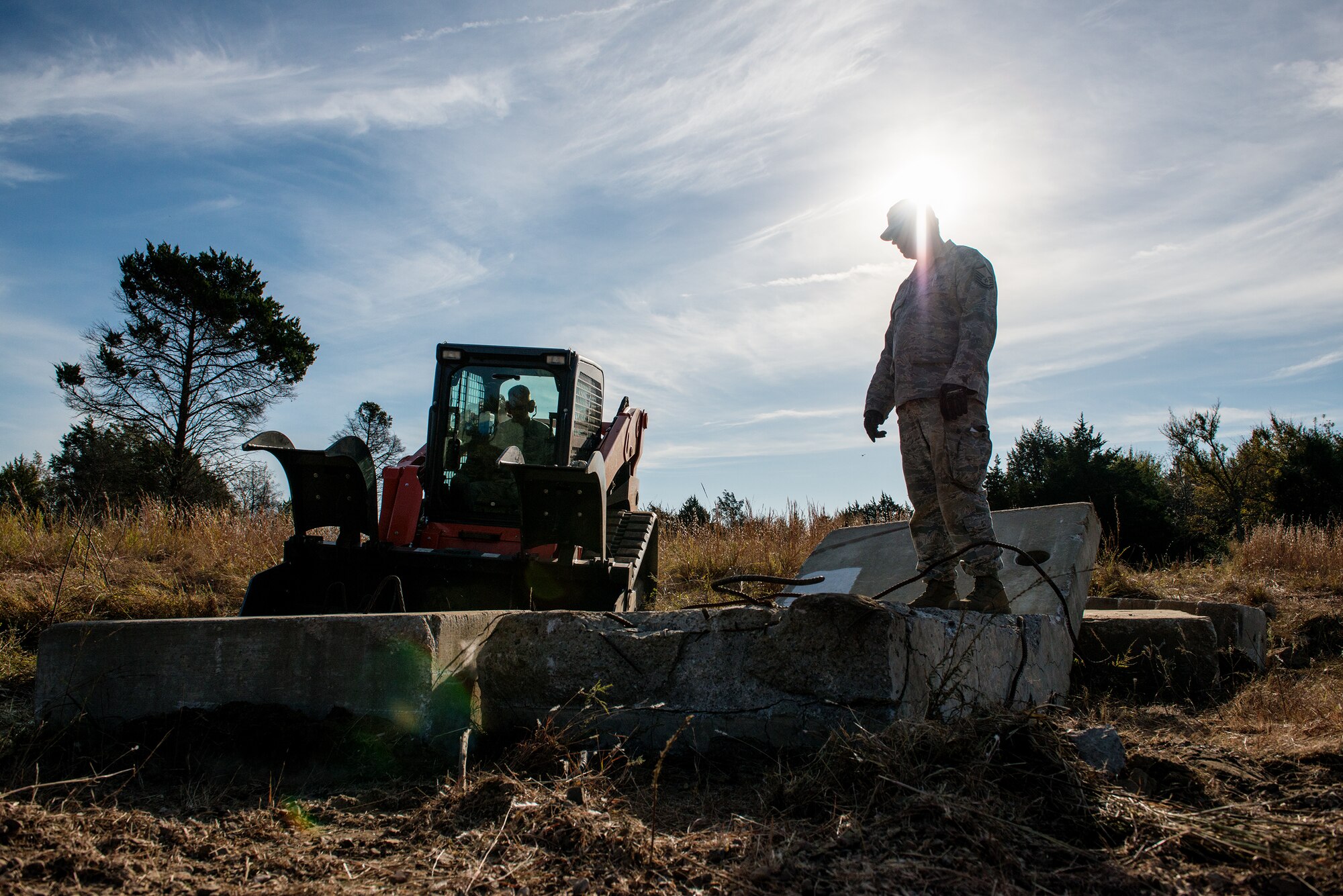 Airmen from the civil engineering squadrons of the 137th Air Refueling Wing, Oklahoma City, and the 138th Fighter Wing, Tulsa, Okla., evaluate the extent of on-site debris during a debris clearance training at Camp Gruber, Oct. 19-23, 2015. The primary goal for the training was to familiarize Airmen with the equipment they will use during a real-world emergency. 