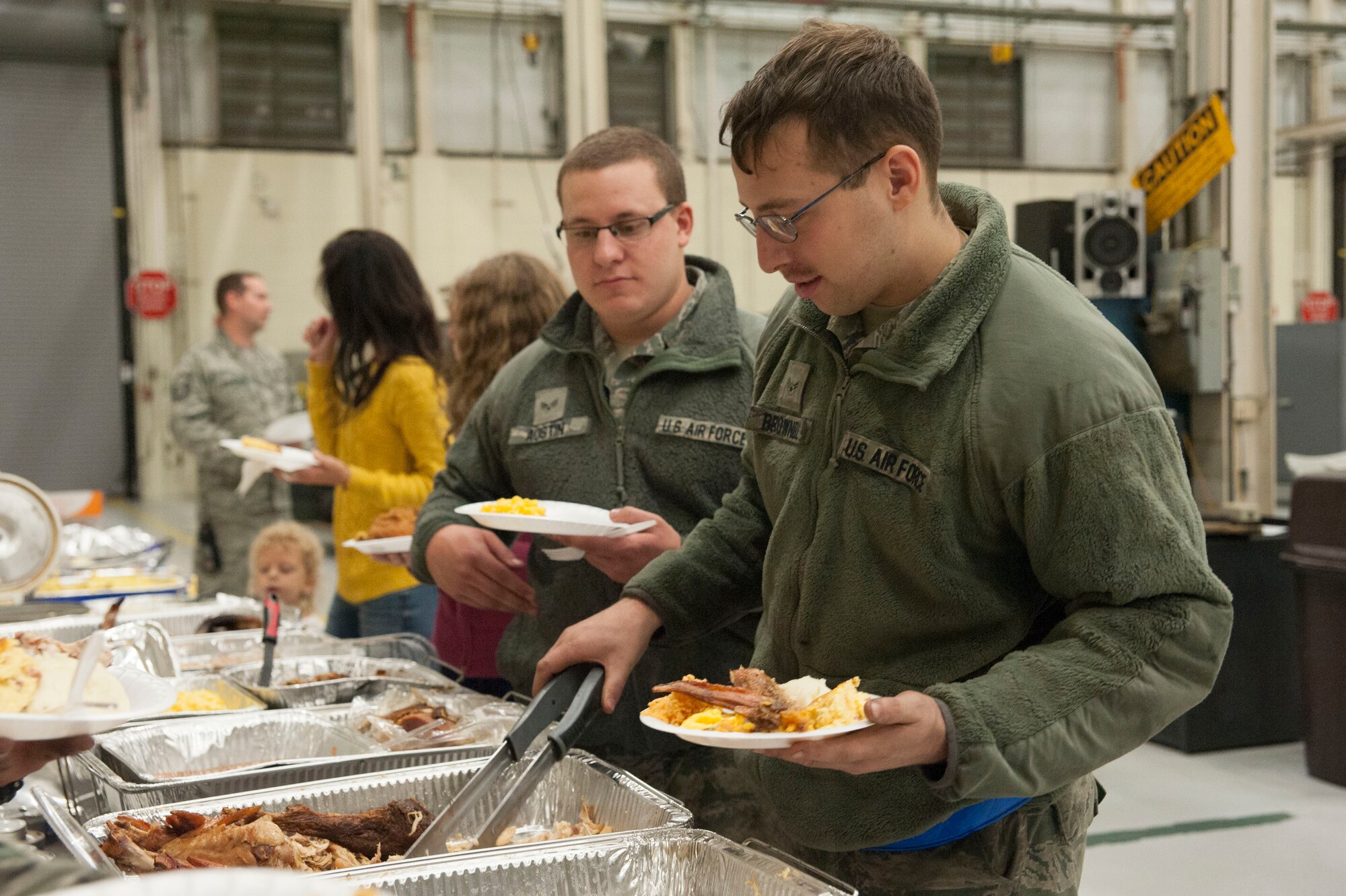 Airman 1st Class Casey Brownell (right) and Senior Airman Michael Austin (center), both aerospace journeyman with the 437th Maintenance Squadron, participate in a Thanksgiving meal for swing-shift workers, Nov. 20, 2015, at Joint Base Charleston, SC.
Swing-shift hours are from 2-11:30 p.m. and is one of three shifts that sustain the aircraft maintenance mission 24 hours per day. (U.S. Air Force photo by Capt. Christopher Love)
