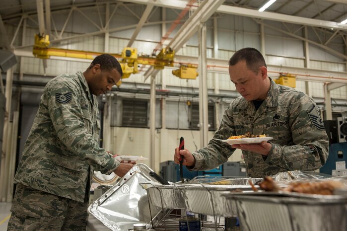 Master Sgt. Sam Gordon, 437th Maintenance Squadron acting first sergeant (right), and Tech. Sgt. Bradley Moorer, 437 MXS electrical and environmental section chief, fill their plates during a Thanksgiving meal, Nov. 20, 2015, at Joint Base Charleston, SC. The aircraft maintenance mission continues 24 hours per day, 365 days per year, including holidays. (U.S. Air Force photo by Capt. Christopher Love)
