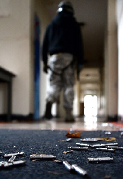 Simulated-munitions’ casings lie on the floor as U.S. Air Force Senior Airman Daniel Duarte, 100th Security Forces Squadron scheduler, acts as an active shooter during expeditionary active shooter training Nov. 23, 2015, on RAF Feltwell, England. The new training, implemented Oct. 1, is designed to prepare deploying Airmen for an environment where firearms are potentially more prevalent, meaning they might be armed and have to protect themselves and others from the threat of an active shooter. (U.S. Air Force photo by Senior Airman Kate Thornton/Released)