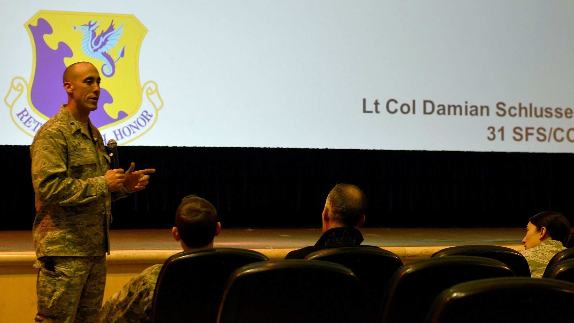 U.S. Air Force Lt. Col. Damian Schlussel, 31st Security Forces Squadron commander, briefs attendees on travel safety during a town hall meeting, Nov. 23, 2015, at Aviano Air Base, Italy. The 31st SFS and Anti-Terrorism office provided important information on European travel restrictions and local area security safety during the upcoming holidays. (U.S. Air Force photo by Airman 1st Class Cary Smith/Released)