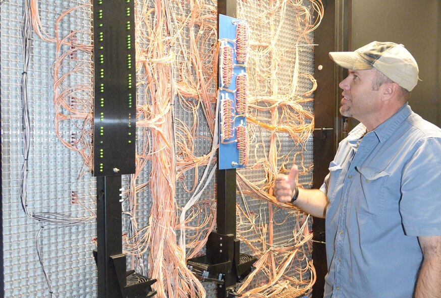 Billy Bandy, 78th Civil Engineer Squadron electrical engineering technician, explains
how exterior electric distribution for Robins is monitored using a giant light map. (U.S. Air Force photo by Ray Crayton)