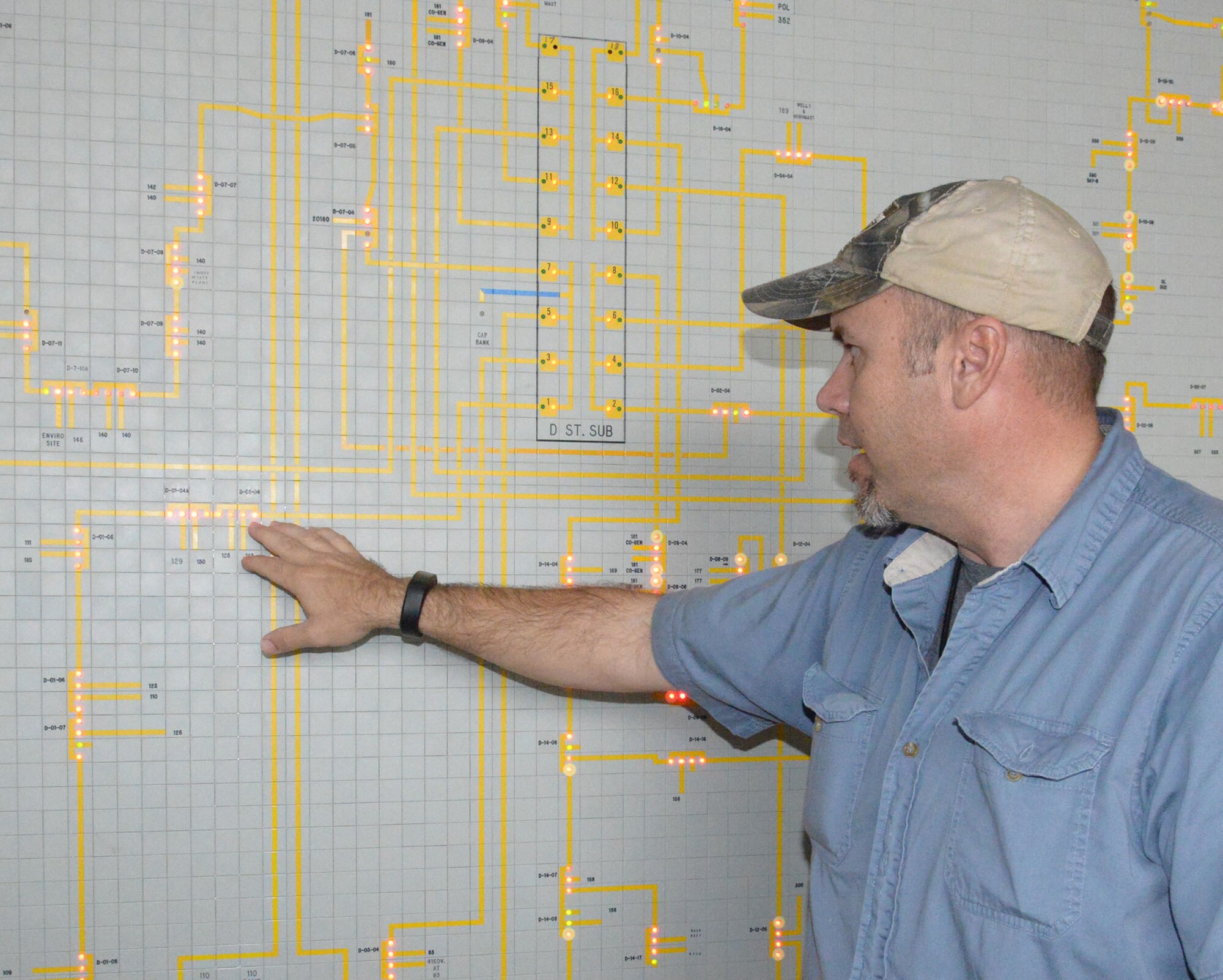 Billy Bandy, 78th Civil Engineer Squadron electrical engineering technician, explains show exterior electric distribution for Robins is monitored using a giant light map. (U.S. Air Force photo by Ray Crayton)