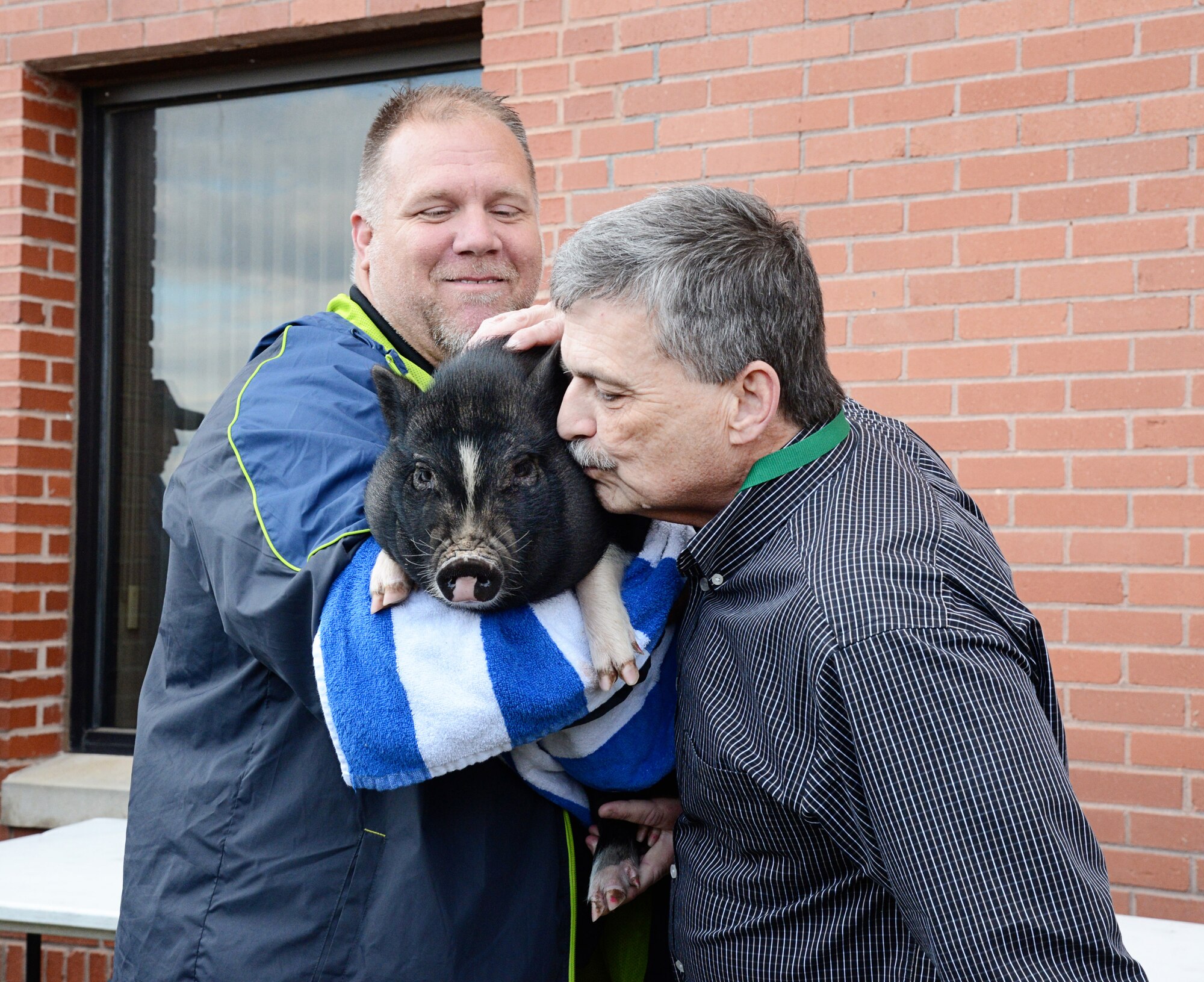 Mike Barrett, civilian leader of the 76th Propulsion Maintenance Group, kisses Okie the pig during the group’s second annual “Kiss the Pig” contest. A total of $1,851 was raised by the group for the Combined Federal Campaign and will all be given to the Wounded Warrior Project. (Air Force photo by Kelly White/Released)

