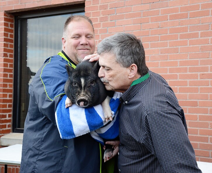 Mike Barrett, civilian leader of the 76th Propulsion Maintenance Group, kisses Okie the pig during the group’s second annual “Kiss the Pig” contest. A total of $1,851 was raised by the group for the Combined Federal Campaign and will all be given to the Wounded Warrior Project. (Air Force photo by Kelly White/Released)

