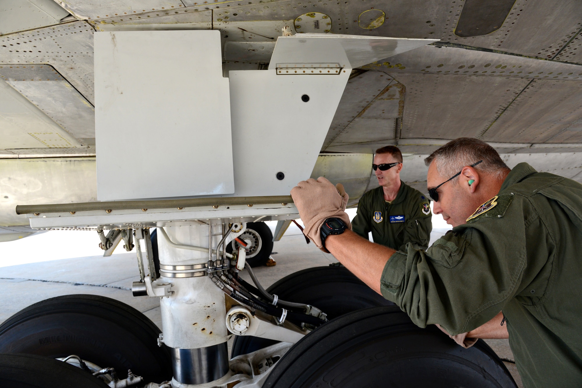 Lt. Col. Brian Rhodarmer and Senior Master Sgt. Tim Brown inspect flight controls on an E-3 AWACS, looking for any kind of leaks or for any components that may not be hooked up properly. (Air Force photo by Kelly White/Released)