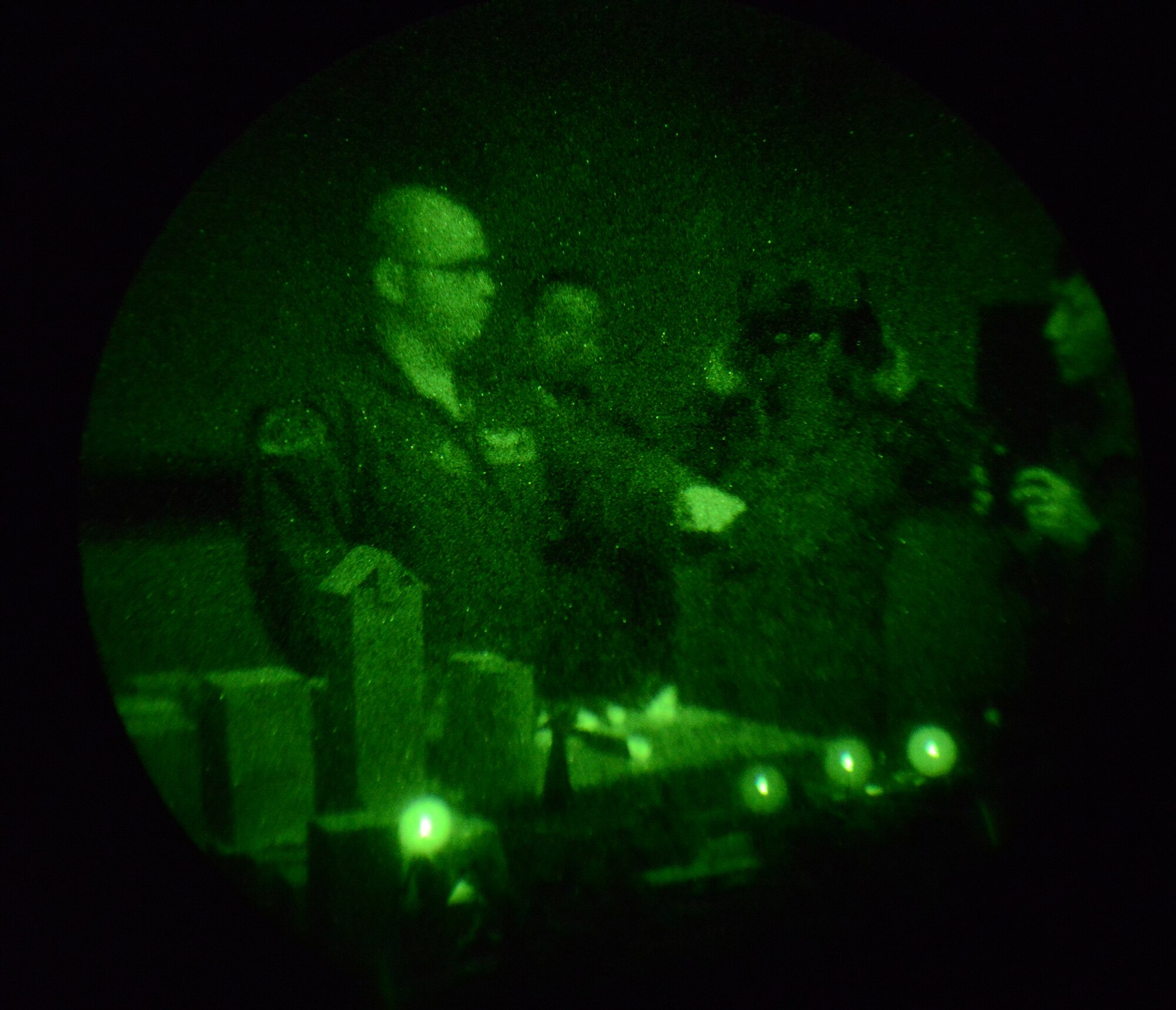 Tech. Sgt. Christopher Rector, 459th Airlift Squadron UH-1N standards and evaluations NCO in charge, demonstrates night vision goggle capabilities to Japan Ground Self-Defense Force members at Yokota Air Base, Japan, Nov. 16, 2015. Rector's diorama demonstrated some of the difficulties pilots face flying at night by simulating the lights of Tokyo as seen through night vision goggles. (U.S. Air Force photo by Senior Airman David C. Danford/Released)