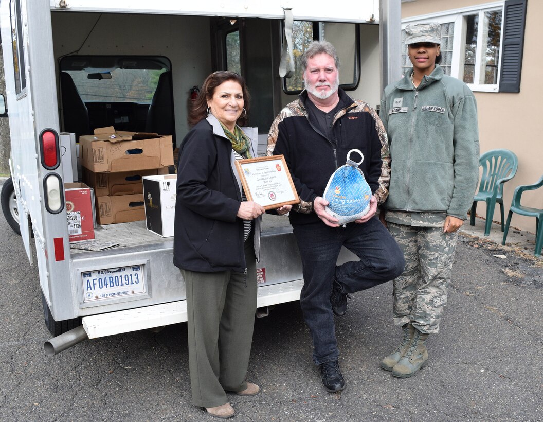 Anna Richar, left, the111th Attack Wing Airman & Family Readiness Center program manager, with office assistant Senior Airman Charlissa Adams take break in stacking a truckload of Thanksgiving bounty to present a certificate of gratitude to American Legion Post 10’s Veteran Services Officer, Chris Dooly, on Nov. 21, 2015 in Fort Washington, Pennsylvania. The 24 full Thanksgiving meals donated by the post are destined for needy area military members and their families. (U.S. Air National Guard photo by Master Sgt. Christopher Botzum/Released)