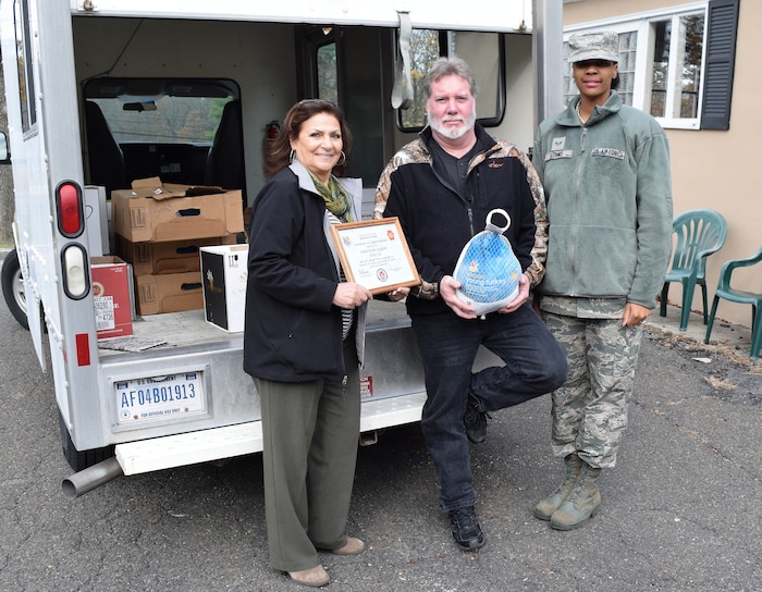 Anna Richar, left, the111th Attack Wing Airman & Family Readiness Center program manager, with office assistant Senior Airman Charlissa Adams take break in stacking a truckload of Thanksgiving bounty to present a certificate of gratitude to American Legion Post 10’s Veteran Services Officer, Chris Dooly, on Nov. 21, 2015 in Fort Washington, Pennsylvania. The 24 full Thanksgiving meals donated by the post are destined for needy area military members and their families. (U.S. Air National Guard photo by Master Sgt. Christopher Botzum/Released)