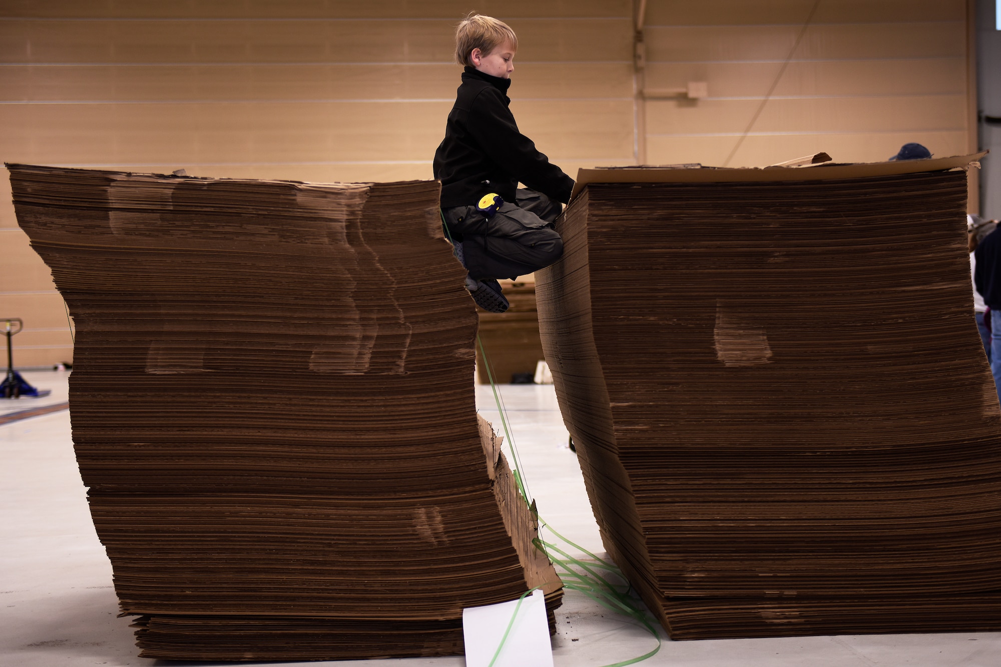 Patrick Jacoby, a Boy Scout from Troop 110, pulls cardboard from a pile during Construction City at the 180th Fighter Wing, Sat. Nov. 21, 2015. The 180th FW partnered with the Boy Scouts of America’s Erie Shores Council to host the annual event for more than 450 scouts, parents and volunteers, who took over the hangar during the one-day event to build cities and bridges entirely out of cardboard. (U.S. Air National Guard photo by Staff Sgt. Shane Hughes/Released)