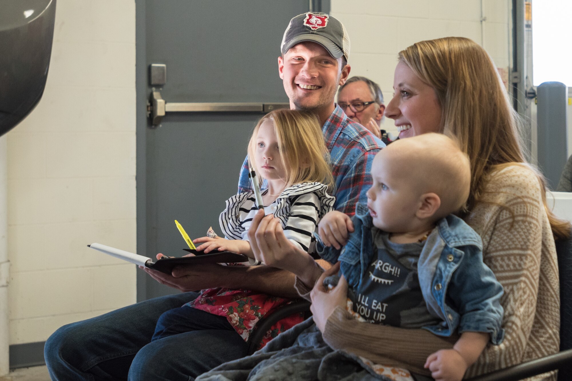 Staff Sgt. Neil Goodlin, a fire team member in the Kentucky Air National Guard’s 123rd Security Forces Squadron, smiles at his wife, Amanda, as the couple see their new minivan, a restored 2012 Dodge Caravan, during an unveiling at Oxmoor Collision Center in Louisville, Ky., Nov. 20, 2015. The van was donated to the Goodlins as part of the National Auto Body Council’s “Recycled Rides” program, which restores wrecked vehicles to like-new condition before giving them to needy individuals. (U.S. Air National Guard photo by Maj. Dale Greer)