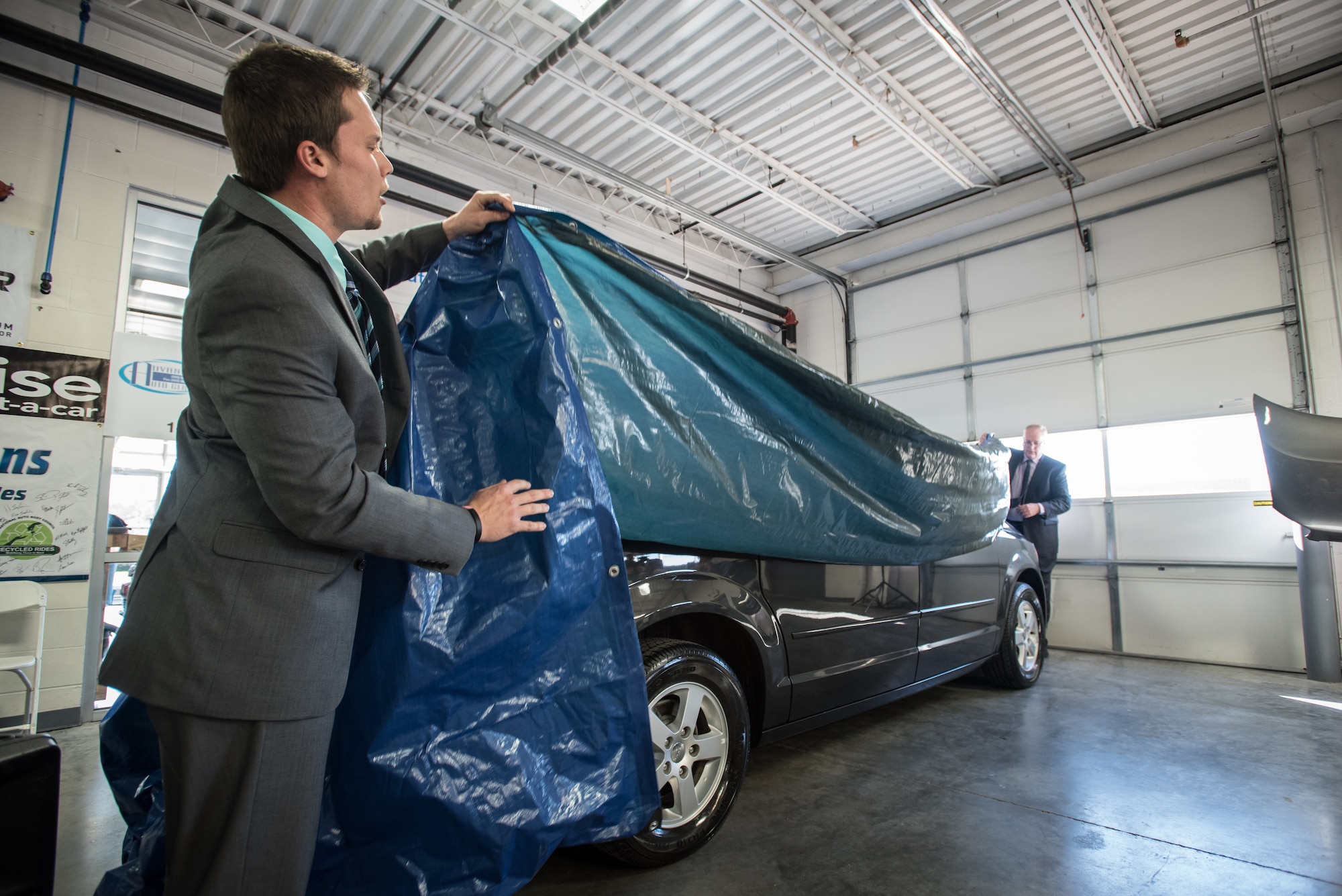 Jeff Lemr (left), manager of Oxmoor Collision Center, and Del Farmer, chief operating officer of Oxmoor Auto Group, unveil a restored Dodge Caravan at Oxmoor Collision in Louisville, Ky., Nov. 20, 2015. The van was being donated to Staff Sgt. Neil Goodlin, a fire team member in the Kentucky Air National Guard’s 123rd Security Forces Squadron, as part of a program that restores wrecked vehicles to like-new condition before giving them to needy individuals. (U.S. Air National Guard photo by Maj. Dale Greer)