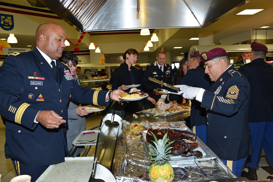 U.S. Army Sgt. 1st Class Norberto Badillo, right, serves a Thanksgiving lunch to U.S. Army Maj. Gen. Darryl A. Williams, commander of U.S. Army Africa, during a celebration in Vicenza, Italy, Nov. 24, 2015. Badillo is a paratrooper assigned to the 173rd Brigade Support Battalion, 173rd Airborne Brigade. U.S. Army photo by Davide Dalla Massara