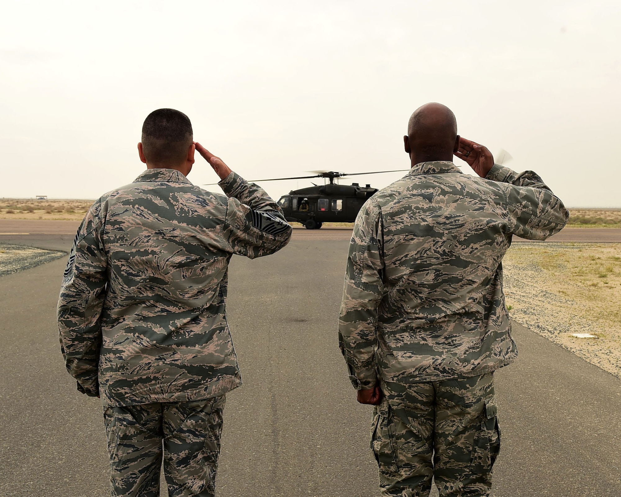 Col. Clarence Lukes Jr., 386th Air Expeditionary Wing commander, and Chief Master Sgt. Richard Vargas, 386th AEW Command Chief Master Sergeant, salute as Central Command commander U.S. Army Gen. Lloyd J. Austin III arrives on the flightline at an undisclosed location in Southwest Asia, Nov. 24, 2015. Austin toured various 386th AEW work centers and interacted with service members expressing gratitude and thanks for their service and support of Operation INHERENT RESOLVE. (U.S. Air Force photo by Staff Sgt. Jerilyn Quintanilla) 