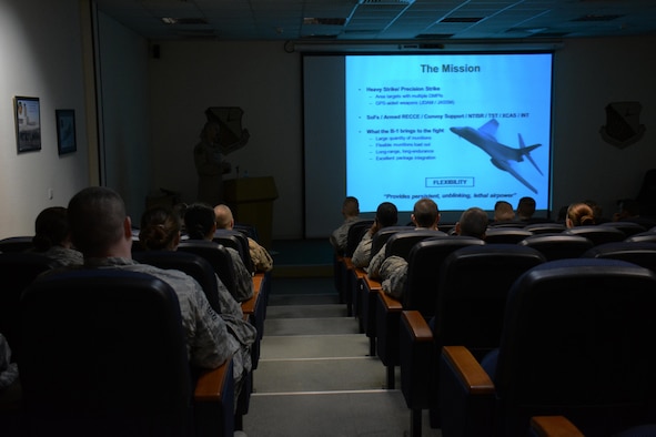 Forty service members listen to a presentation on the mission and capabilities of the B-1 Lancer at Al Udeid Air Base, Qatar Nov. 24. The presentation kicked-off a tour of the aircraft which also featured videos showcasing strikes the bomber has carried out. Service members were selected for the tour by their unit leadership for outstanding performance. (U.S. Air Force photo by Tech. Sgt. James Hodgman/Released)