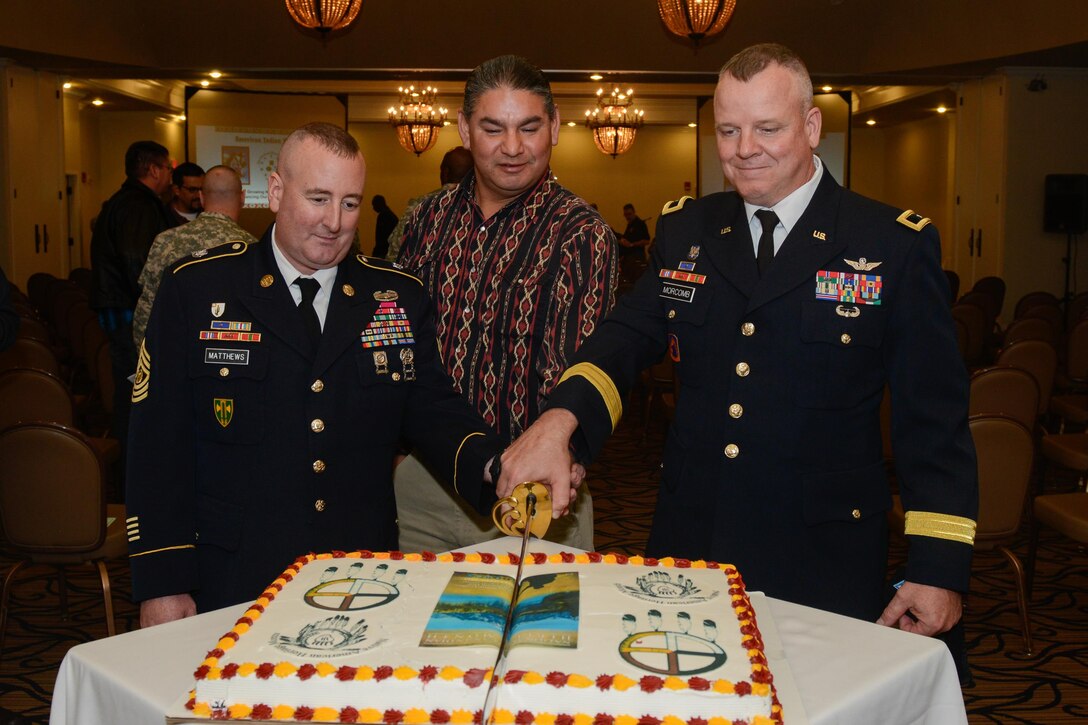 Command Sgt. Maj. JamesPeter Matthews, Matthew “Black Eagle Man” Cordes and Brig. Gen. Scott Morcomb, commanding general of the 11th Theater Aviation Command, cut cake during the National American Indian Heritage Month observance Nov. 20 at Fort Knox, Ky. U.S. Army Reserve soldiers from the 11th Theater Aviation Command (TAC), headquartered at Fort Knox, co-hosted this event in order to recognize the significant contributions that American Indians made to the establishment and growth of the U.S. The 11th Theater Aviation Command (TAC) is the only aviation command in the Army Reserve. The 11th TAC has two missions, functioning as both a warfighting headquarters and as a functional command. As warfighting command, the 11th TAC provides command & control, staff planning, and supervision for two aviation brigades and one air traffic service battalion. As a functional command the 11th TAC provides command and control for all Army Reserve Aviation. (Photo by Fort Knox Visual Information)