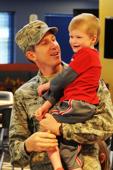 U.S. Air Force Col. Thomas Kunkel, 23d Wing commander, and one of his sons welcome Airmen, retirees, and family members on Thanksgiving Day at the Georgia Pines Dining Facility, Nov. 26, 2015, at Moody Air Force Base, Ga. Kunkel wanted to ensure that everyone was welcomed and enjoyed a delicious meal on Thanksgiving Day. (U.S. Air Force photo by Capt. Korey Fratini/Released)