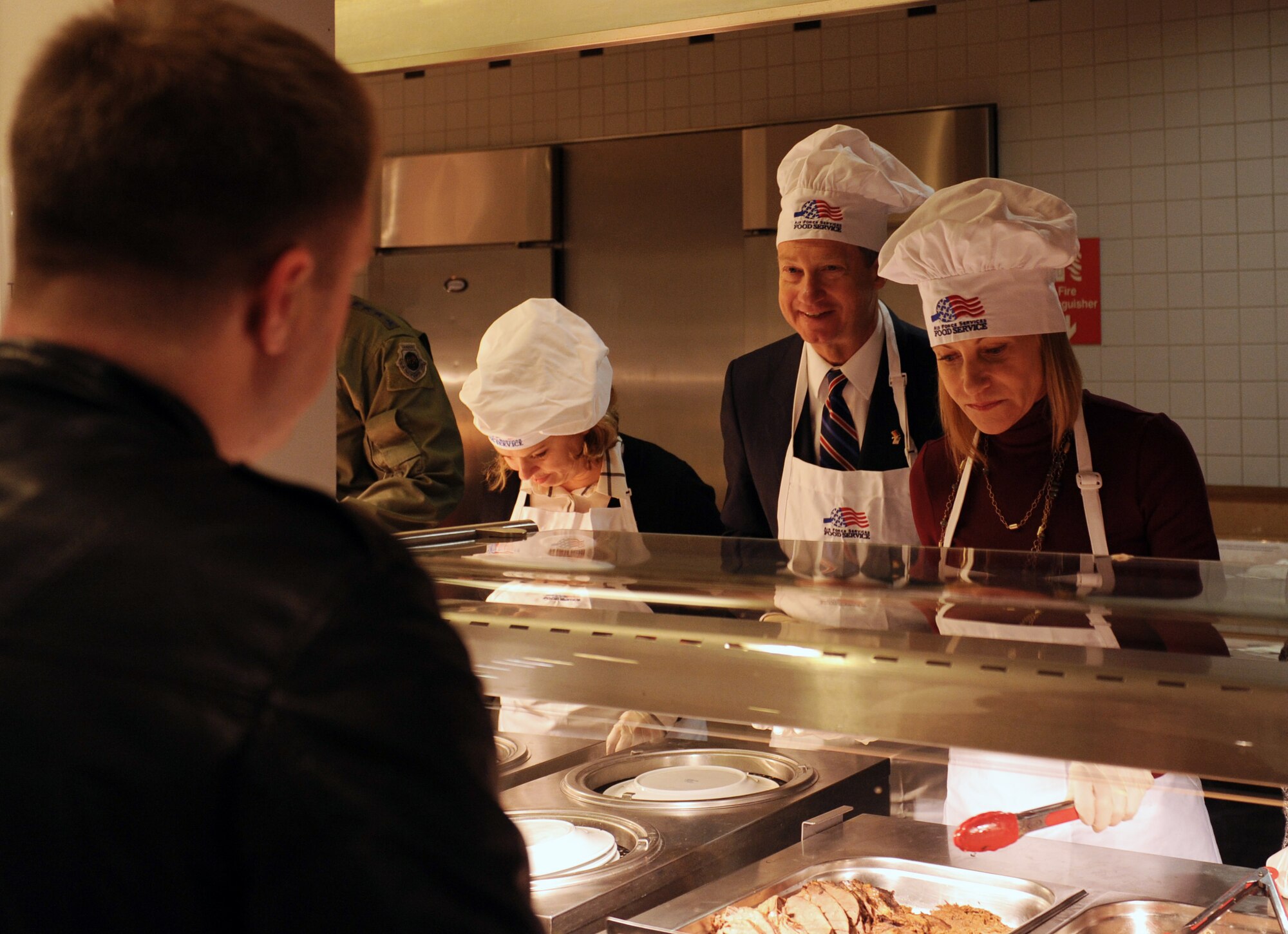 John B. Emerson, U.S. Ambassador to Germany, speaks with an airman during a Thanksgiving meal at the Rheinland Inn Dining Facility Nov. 26, 2015, at Ramstein Air Base, Germany. Ambassador Emerson and AF senior leaders served meals to Airmen and their families. The event was also open to retirees. (U.S. Air Force photo/Staff Sgt. Sharida Jackson)