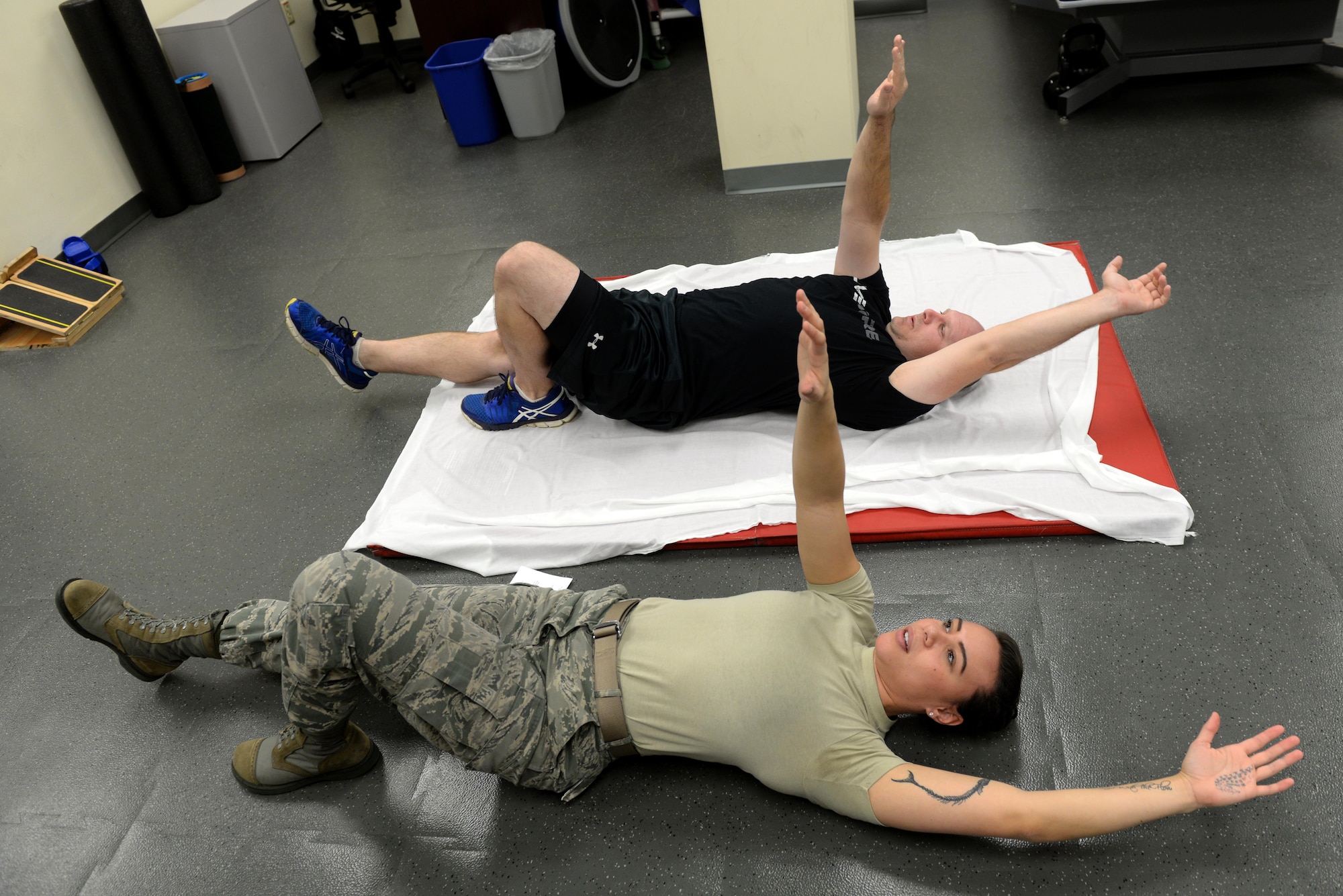 Staff Sgt. Amber Coley, a 4th Medical Operations Squadron physical therapy technician, demonstrates an exercise for Tech. Sgt. Jared Rhynehart, a 4th Aircraft Maintenance Squadron lead support team member, during a rehabilitation session, Nov. 18, 2015, at Seymour Johnson Air Force Base, North Carolina. The physical therapists assign several different exercises per session with difficulty dependent on the patient’s injury or pain area. (U.S. Air Force photo/Airman 1st Class Ashley Williamson)