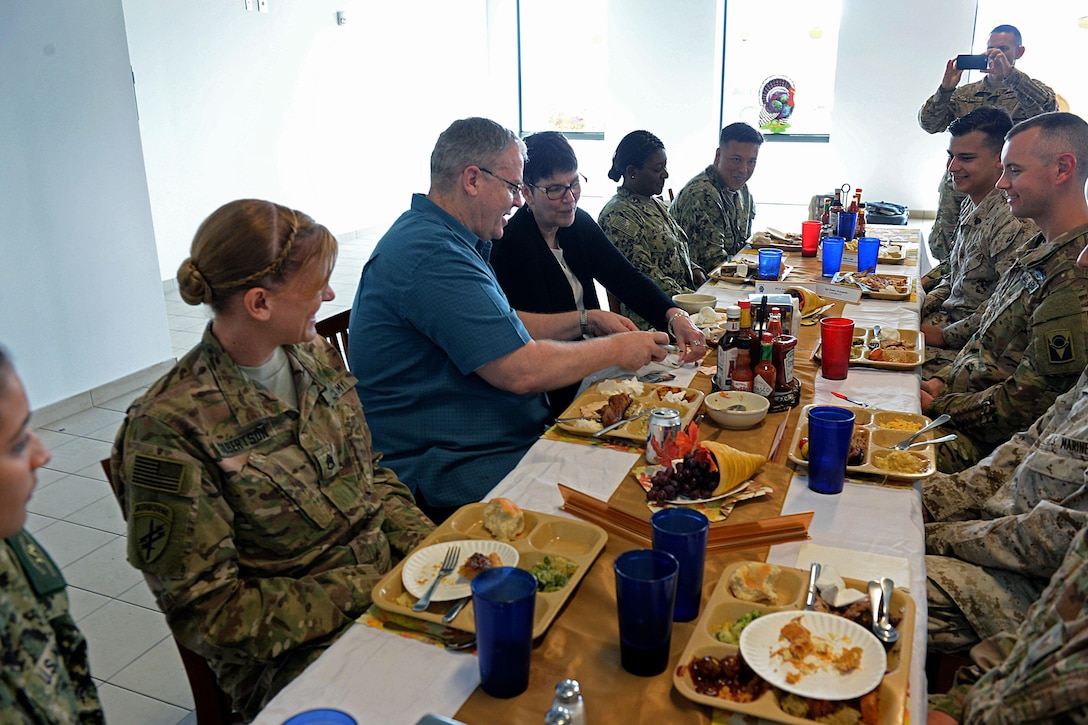 U.S. Deputy Defense Secretary Bob Work, center left, signs a flag he received from a service member after Thanksgiving lunch on Camp Lemonnier, Djibouti, Nov. 26, 2015. DoD photo by Army Sgt. 1st Class Clydell Kinchen