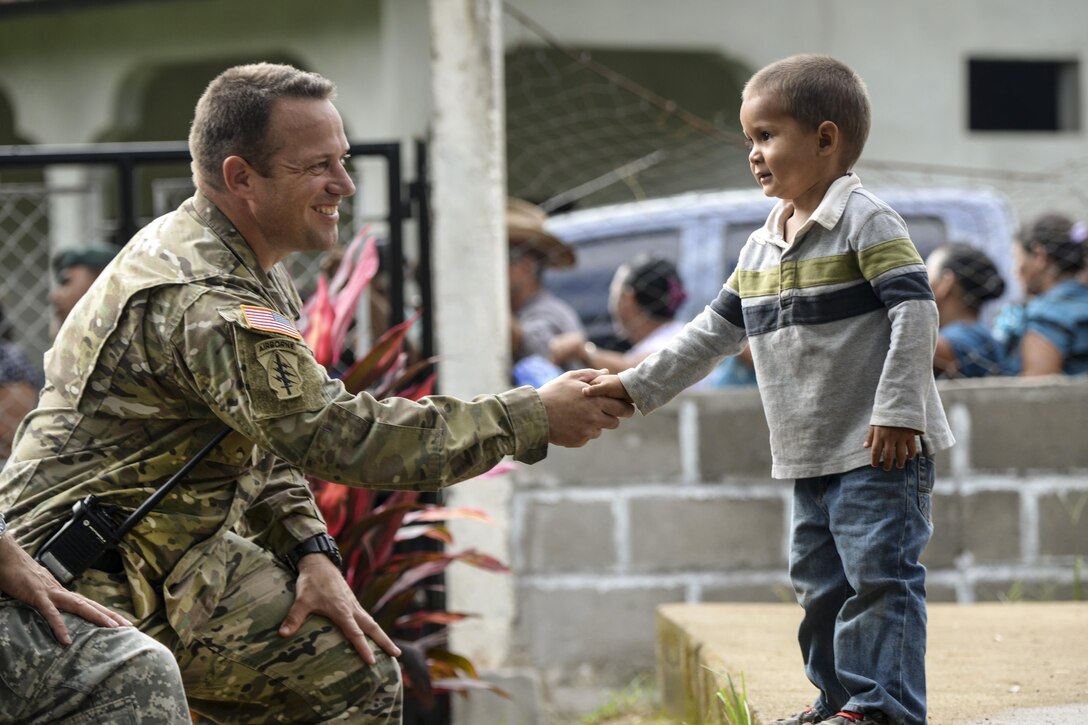 U.S. Army Capt. John Dills shakes hands with a boy during a medical readiness training exercise in San Jose De Rio Pinto, Honduras, Nov. 12, 2015. Dills is the tactical officer in charge. The exercise provides military members with essential training in austere locations and helps build local community relations in the host country. U.S. Air Force Photo by Senior Airman Westin Warburton