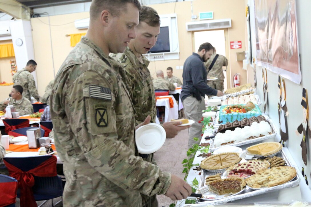 American soldiers with the 10th Mountain Division enjoy Thanksgiving dinner at the Tactical Base Gamberi dining facility in Laghman province, Afghanistan, Nov. 26, 2015. The dining facility’s staff provided holiday decorations along with a top-notch, six-course Thanksgiving meal featuring traditional favorites with tasty desserts. The division’s senior leaders manned the serving lines. U.S. Army photo by Maj. Asha Cooper