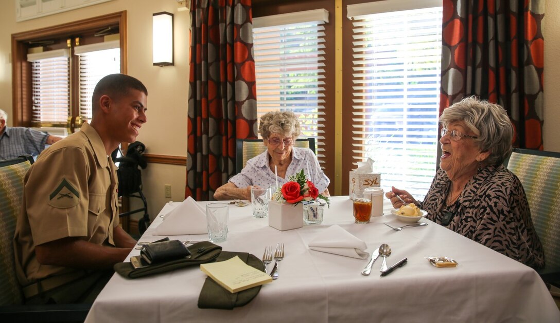 Lance Corporal Jason Feliciano, a motor vehicle operator with Combat Logistics Battalion 5, Combat Logistics Regiment 1, 1st Marine Logistics Group, talks with resident Sylvia Winderbaum at Fairwinds-Ivey Ranch Retirement Community in Oceanside, California, Aug. 26, 2015. In conjunction with the Single Marines Program on Marine Corps Base Camp Pendleton and just in time for Thanksgiving, the Fairwinds-Ivey Ranch Retirement Community hosts a dinner for volunteering Marines and retirees on the final Wednesday of every month from 4 p.m. to 6 p.m. (USMC photo by Lance Cpl. Devan K. Gowans/Released)