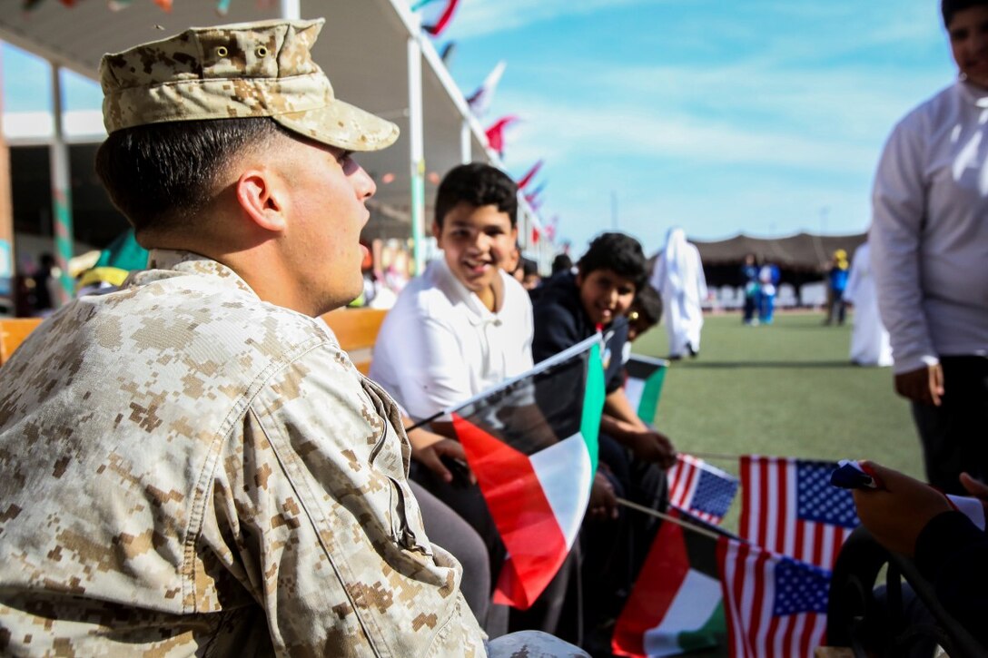 A U.S. Marine, assigned to Special Purpose Marine Air Ground Task Force—Crisis Response—Central Command, interacts with students of a local middle school during a celebration commemorating the 25th anniversary of the liberation of Kuwait in Kuwait City, Nov. 17, 2015. In attendance of the event was Douglas A. Silliman, the U.S. ambassador to Kuwait, along with Kuwaiti dignitaries and members of the U.S. armed forces. The American service members were recognized during the ceremony and had the opportunity to interact with students and local community members. (U.S. Marine Corps Photo by Sgt. Rick Hurtado / Released)