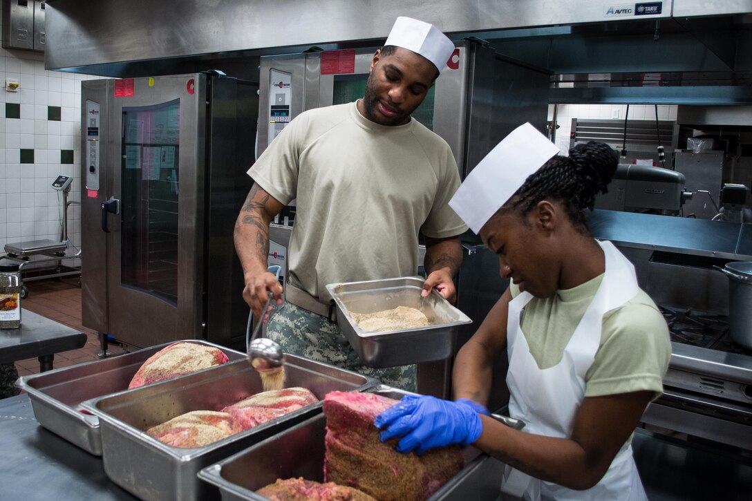 Green Berets spread seasoning over steamship round roasts as they and others prepare a Thanksgiving dinner in the unit’s dining facility on Eglin Air Force Base, Fla., Nov. 23, 2015. The soldiers, assigned to the 7th Special Forces Group and other cooks, prepared over 600 lbs. of turkey, 115 lbs. of steamship round and 184 lbs. of ham for serving to the group’s soldiers, families and friends. U.S. Army photo by Maj. Thomas Cieslak