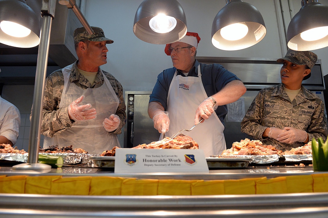 U.S. Deputy Defense Secretary Bob Work, center, talks to U.S. airmen while serving Thanksgiving dinner to service members on Al Udeid Air Base, Qatar, Nov. 26, 2015. DoD photo by Army Sgt. 1st Class Clydell Kinchen