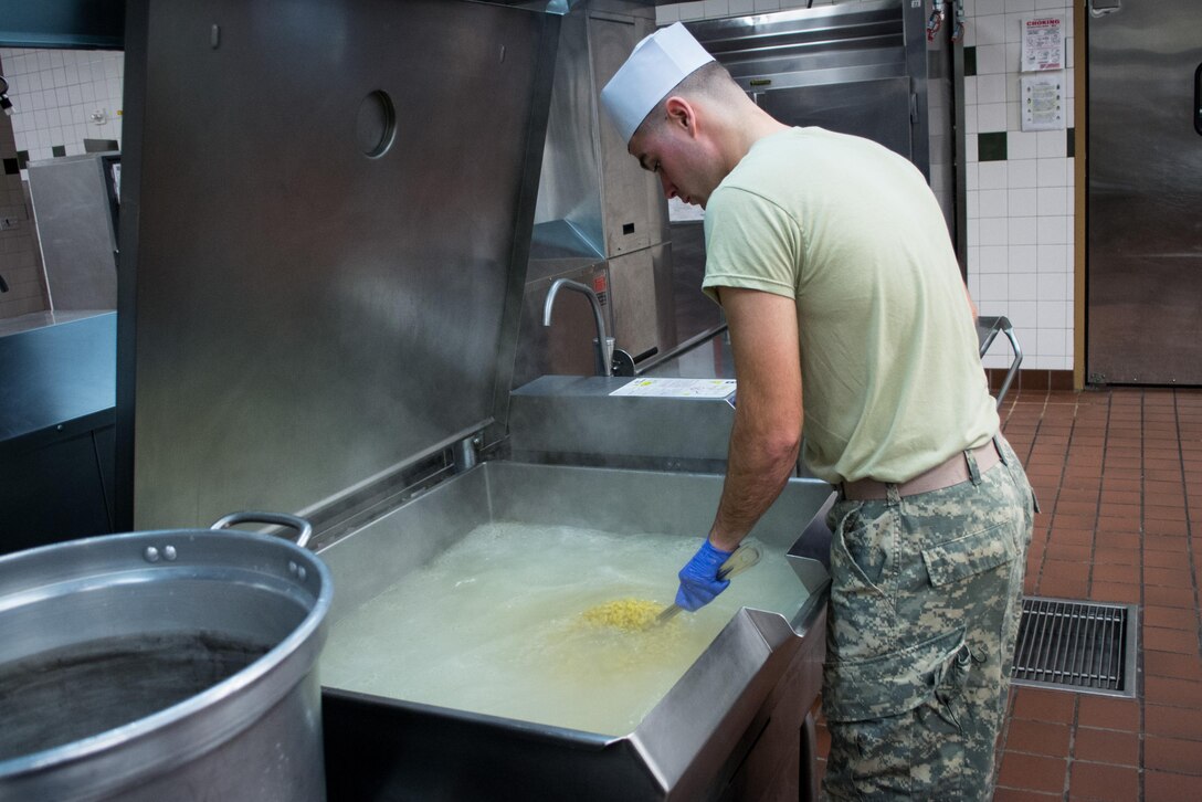 A Green Beret stirs a vat of macaroni as he prepares a Thanksgiving dinner in the unit’s dining facility on Eglin Air Force Base, Fla., Nov. 23, 2015. U.S. Army photo by Maj. Thomas Cieslak