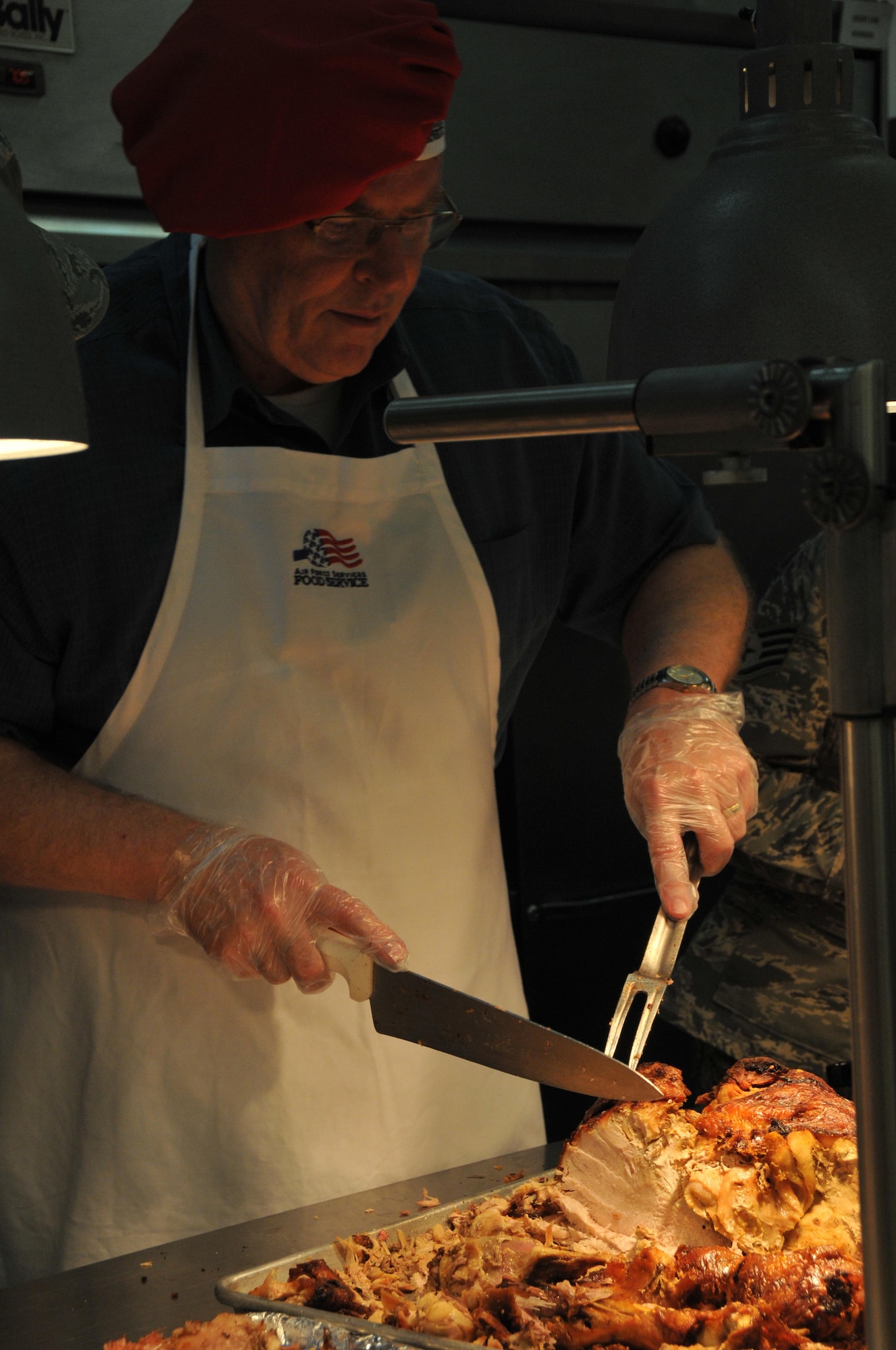 Deputy Secretary of Defense Bob Work shows off his turkey carving skills Thanksgiving Day at the Blatchford-Preston Complex dining facility on base. Service members Thanksgiving meal included turkey, roast beef, mash potatoes, vegetables and a variety of deserts and for many a thank you from the Deputy Secretary of Defense. (U.S. Air Force Photo by Tech. Sgt. Terrica Y. Jones)